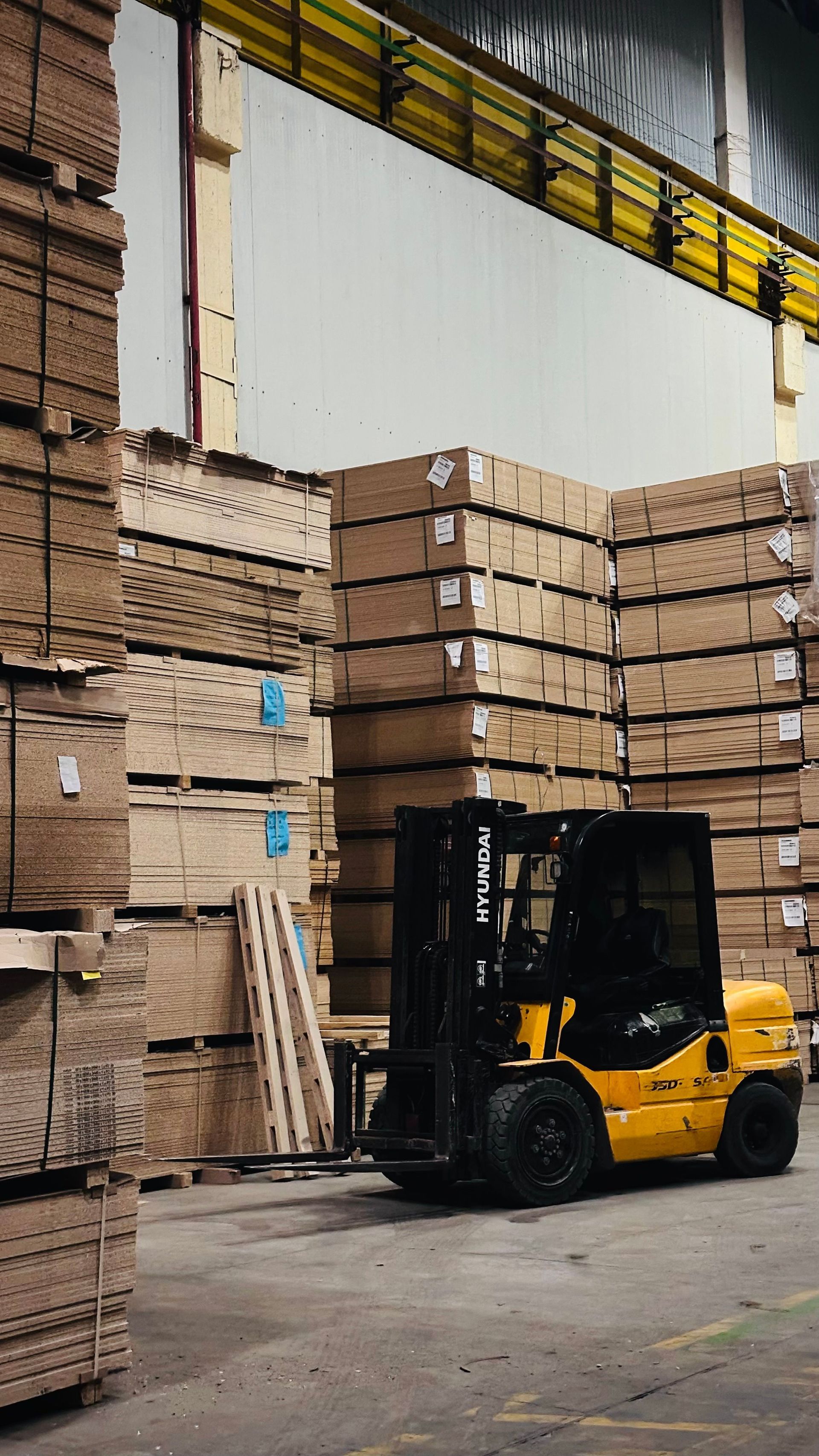 Forklift loading stacked cardboard freight in a warehouse, illustrating Texas motor truck cargo insurance coverage
