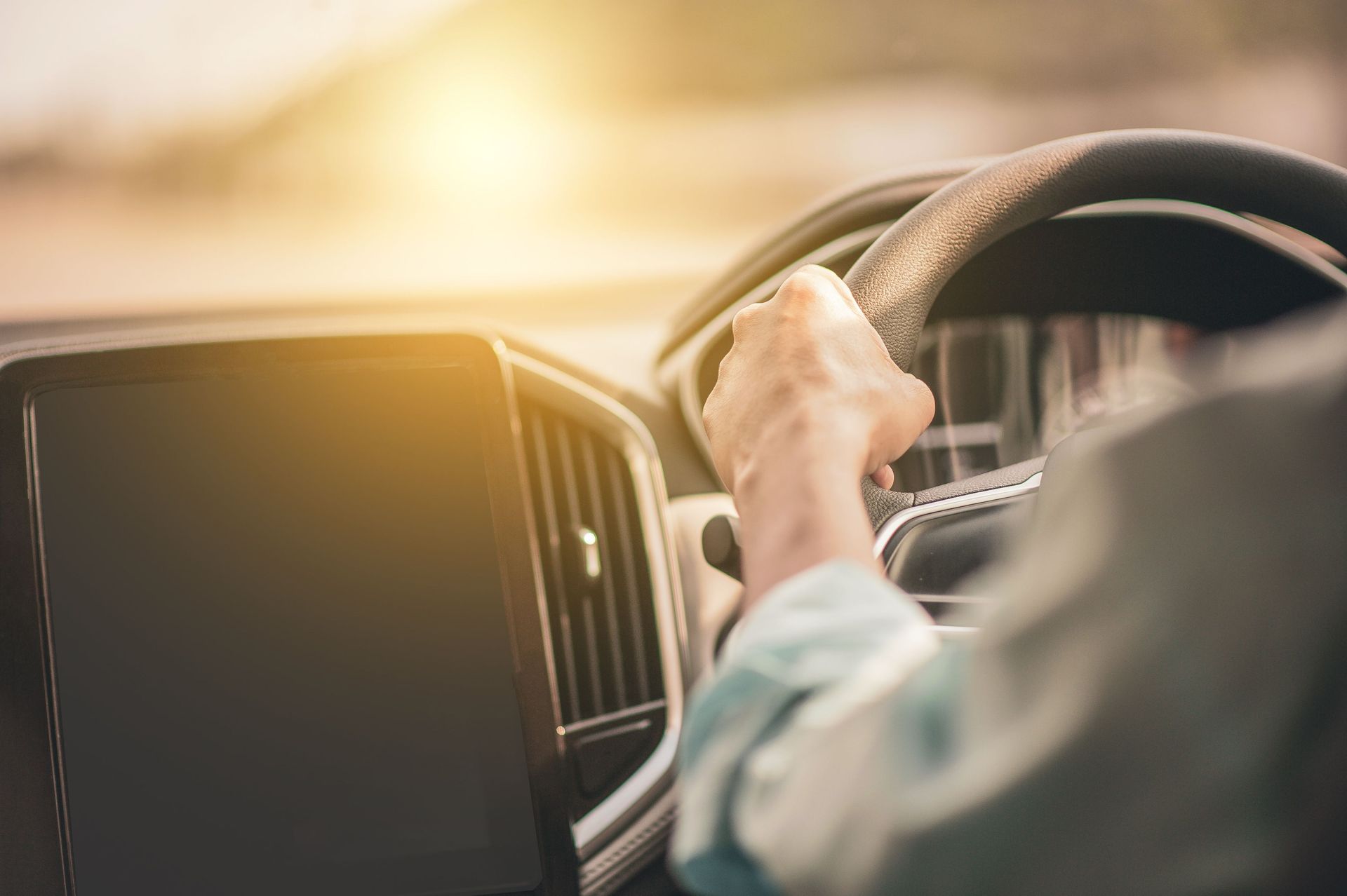 Driver's hand on the steering wheel in bright sunlight, driving legally again on a Texas ODL