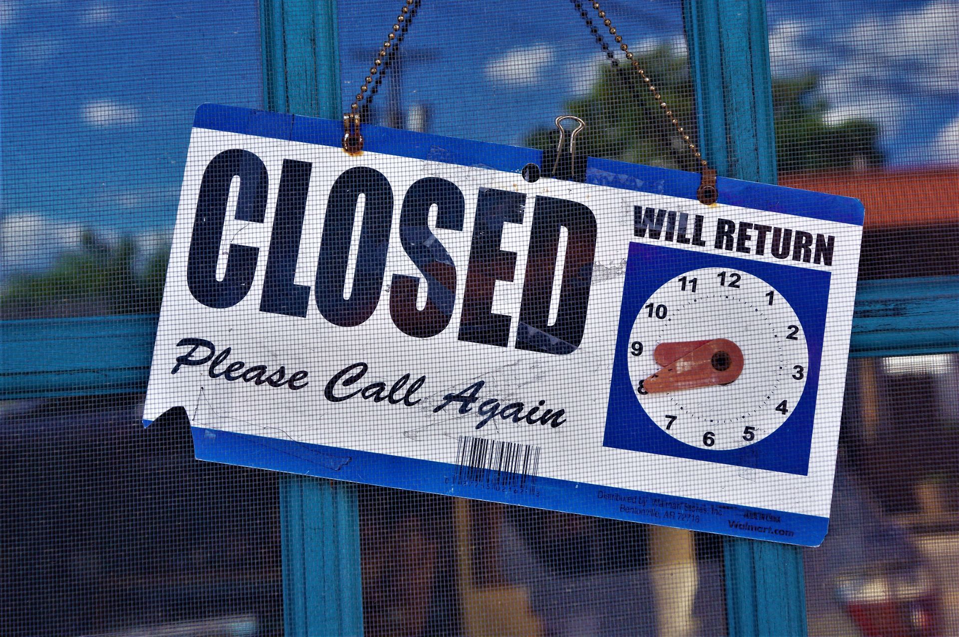 A closed sign hanging in the door of a small professional office on a weekday, the owner out