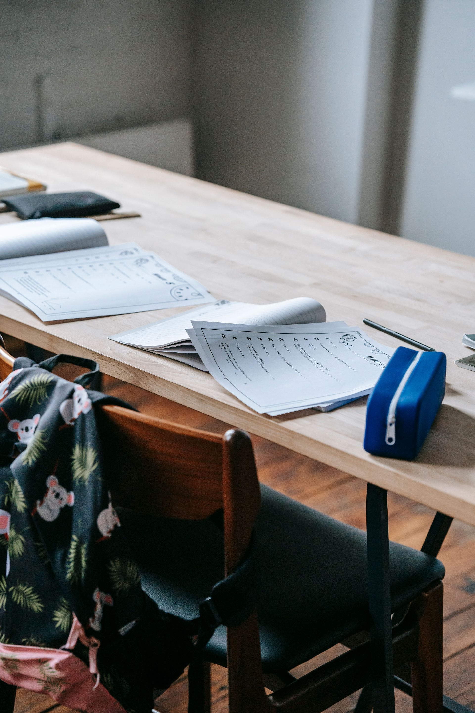 School supplies, notebooks and a backpack on a kitchen table during back-to-school season