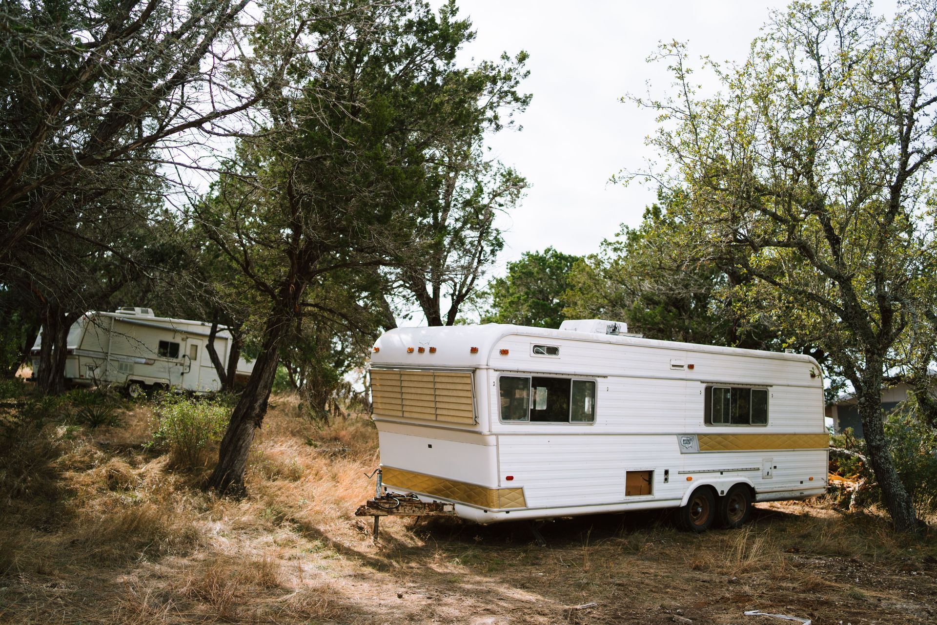 Fifth-wheel RV set up on a long-term site at a North Texas RV park with the awning out and chairs