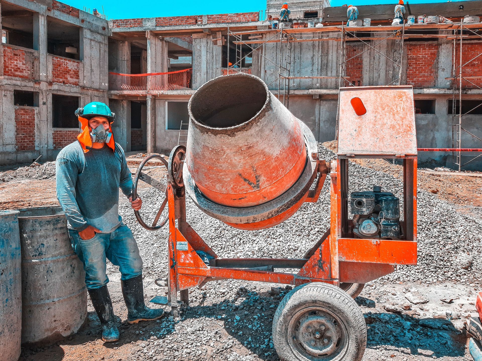 Texas construction worker at a job site with a concrete mixer, illustrating contractor performance and payment bonds