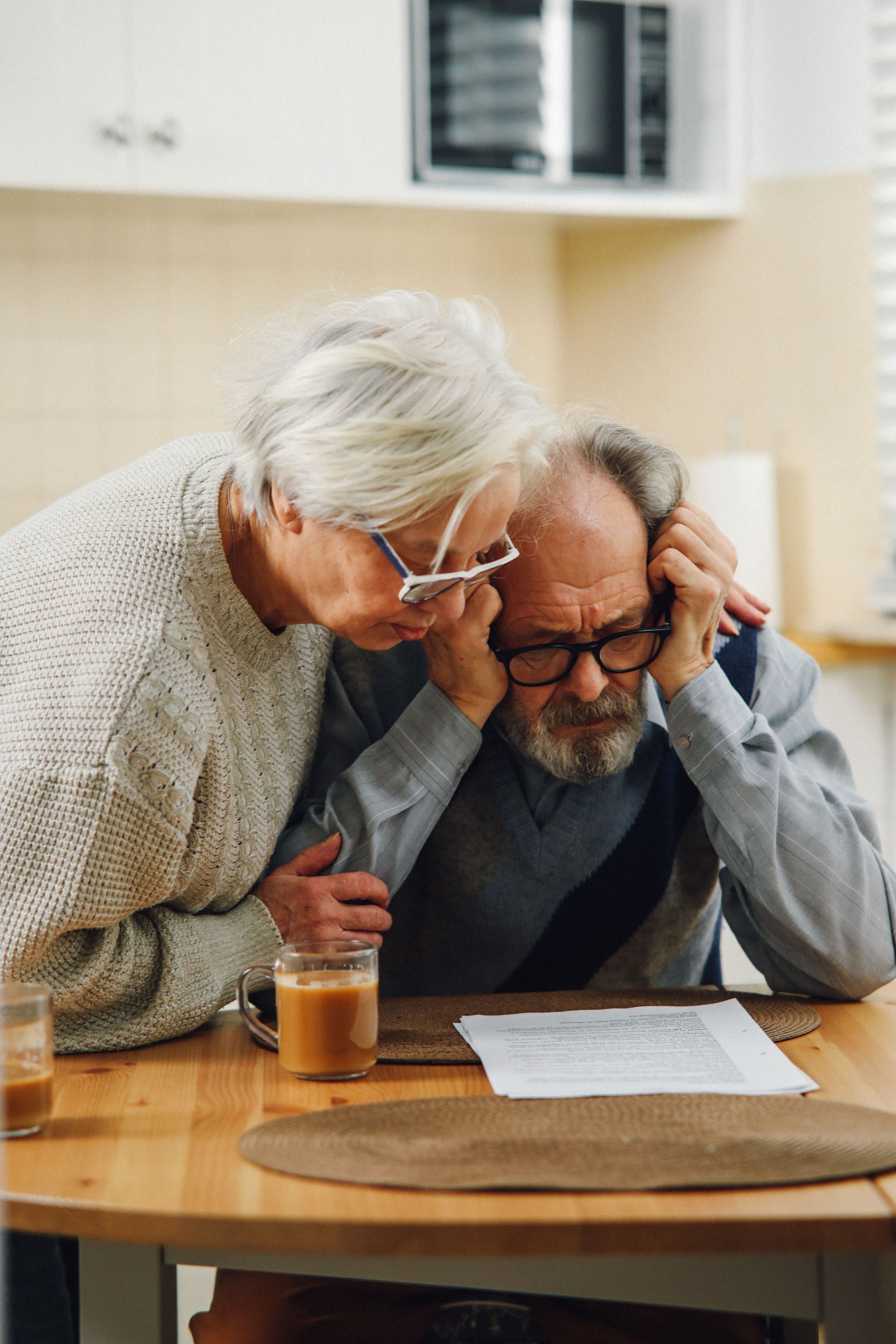 Older Texas couple reviewing life insurance paperwork together at a kitchen table, final expense ins