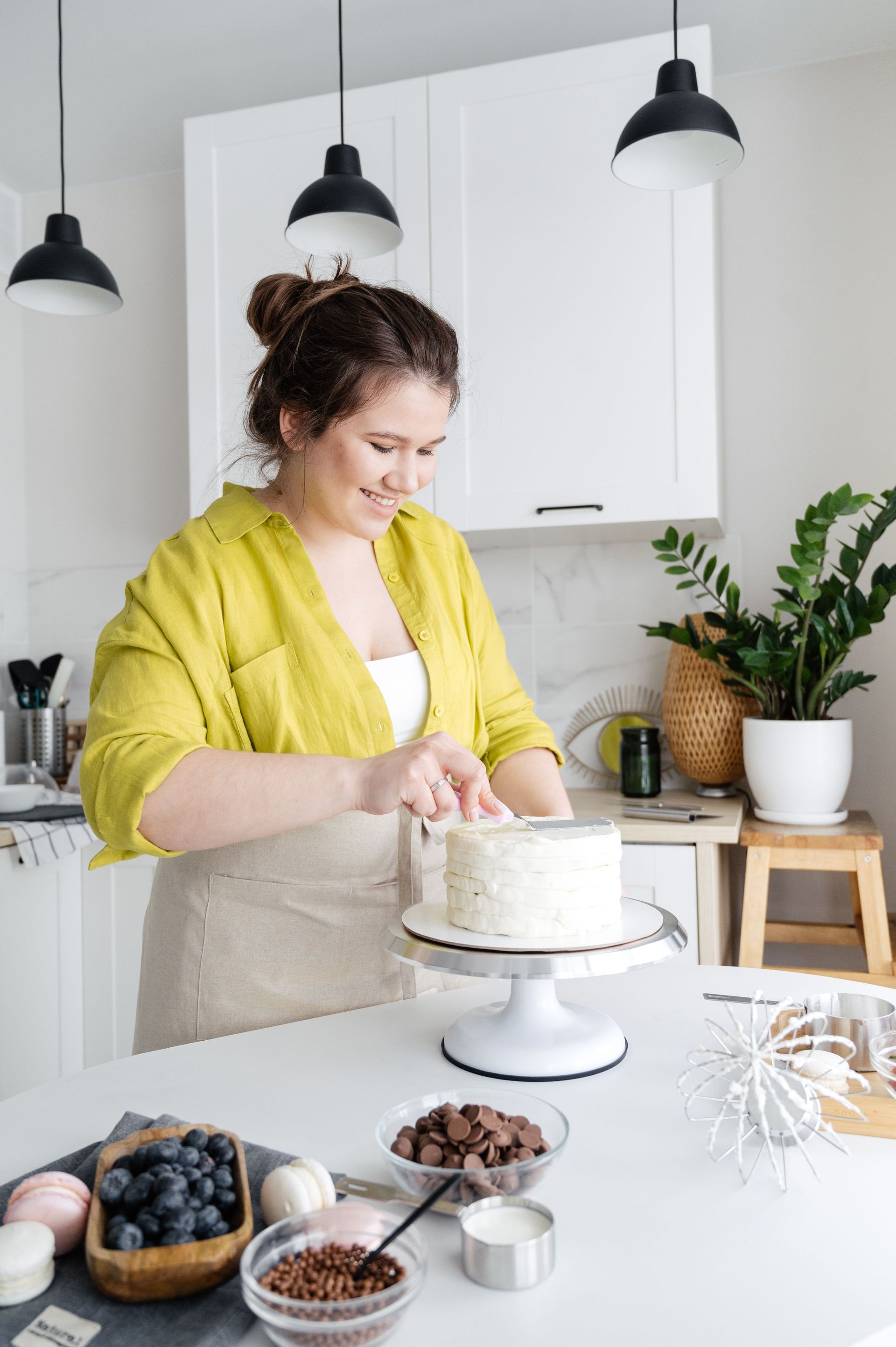 A baker finishing a tiered cake in her own kitchen, the kind of home business a homeowners policy excludes
