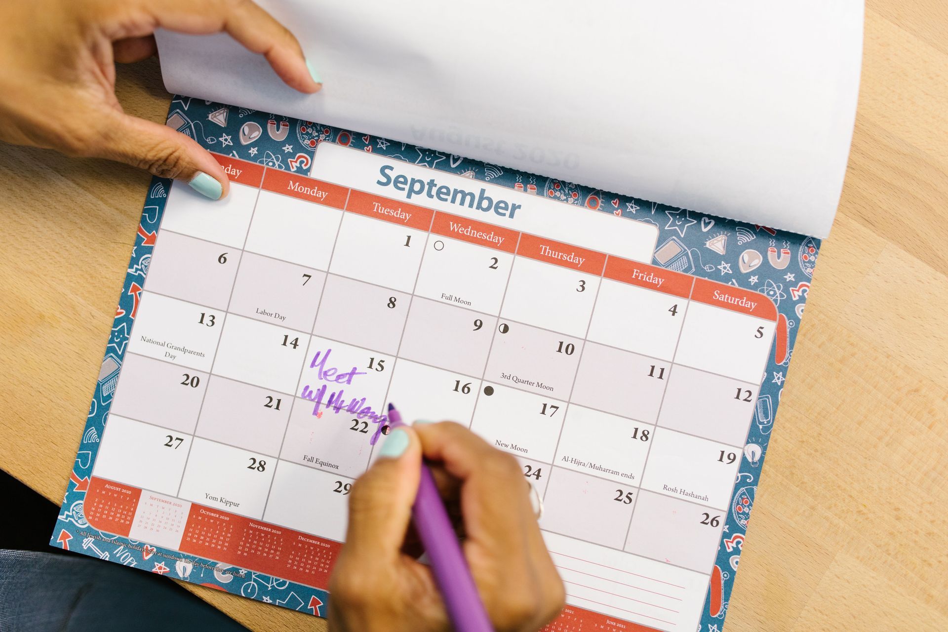 Family calendar on a kitchen wall packed with the school runs and appointments one parent manages
