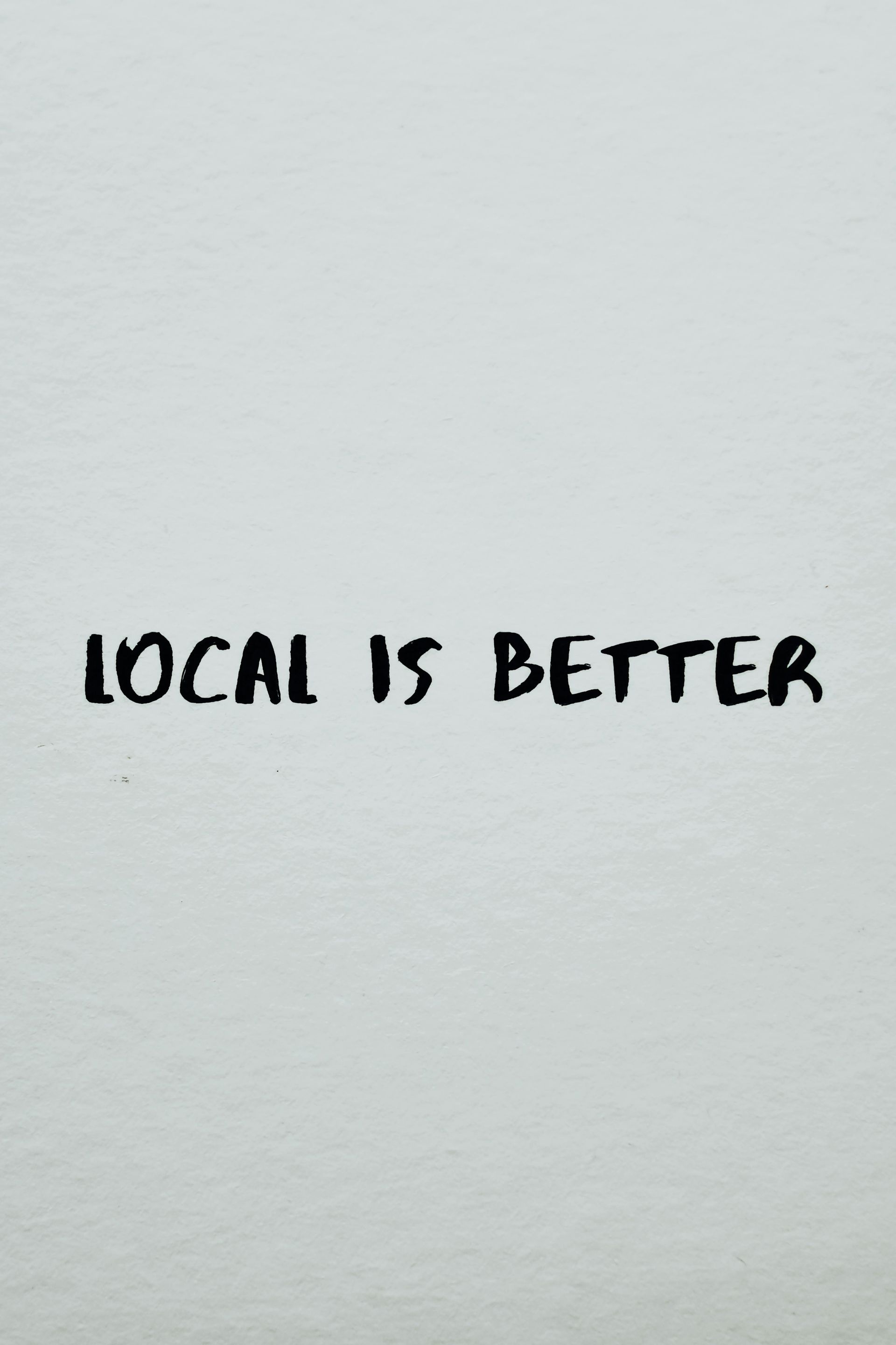 Handwritten text on a light gray background reads “LOCAL IS BETTER.”