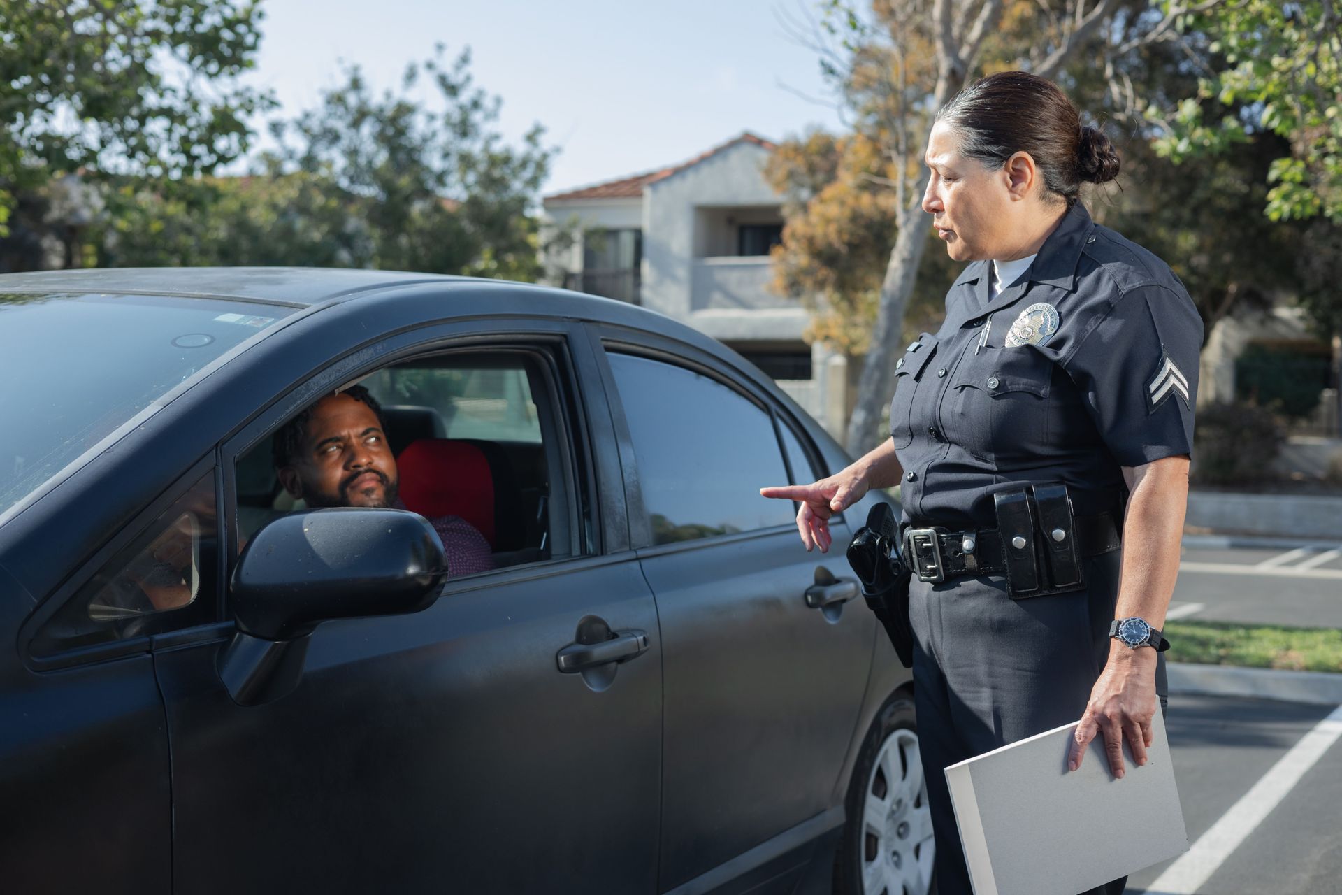 Texas police officer at a driver's window during a traffic stop, illustrating how a speeding ticket can affect car insurance
