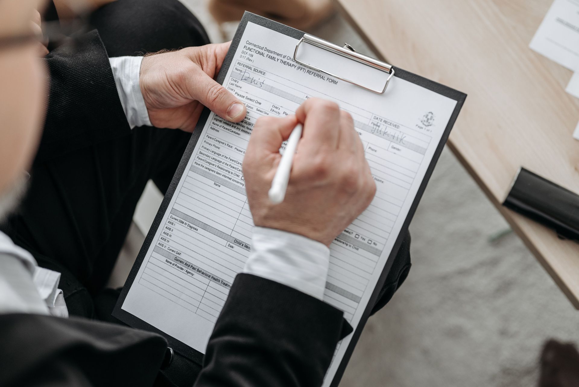 Hands signing a contract on a clipboard, the insurance requirements section that sets the limit a sub must carry