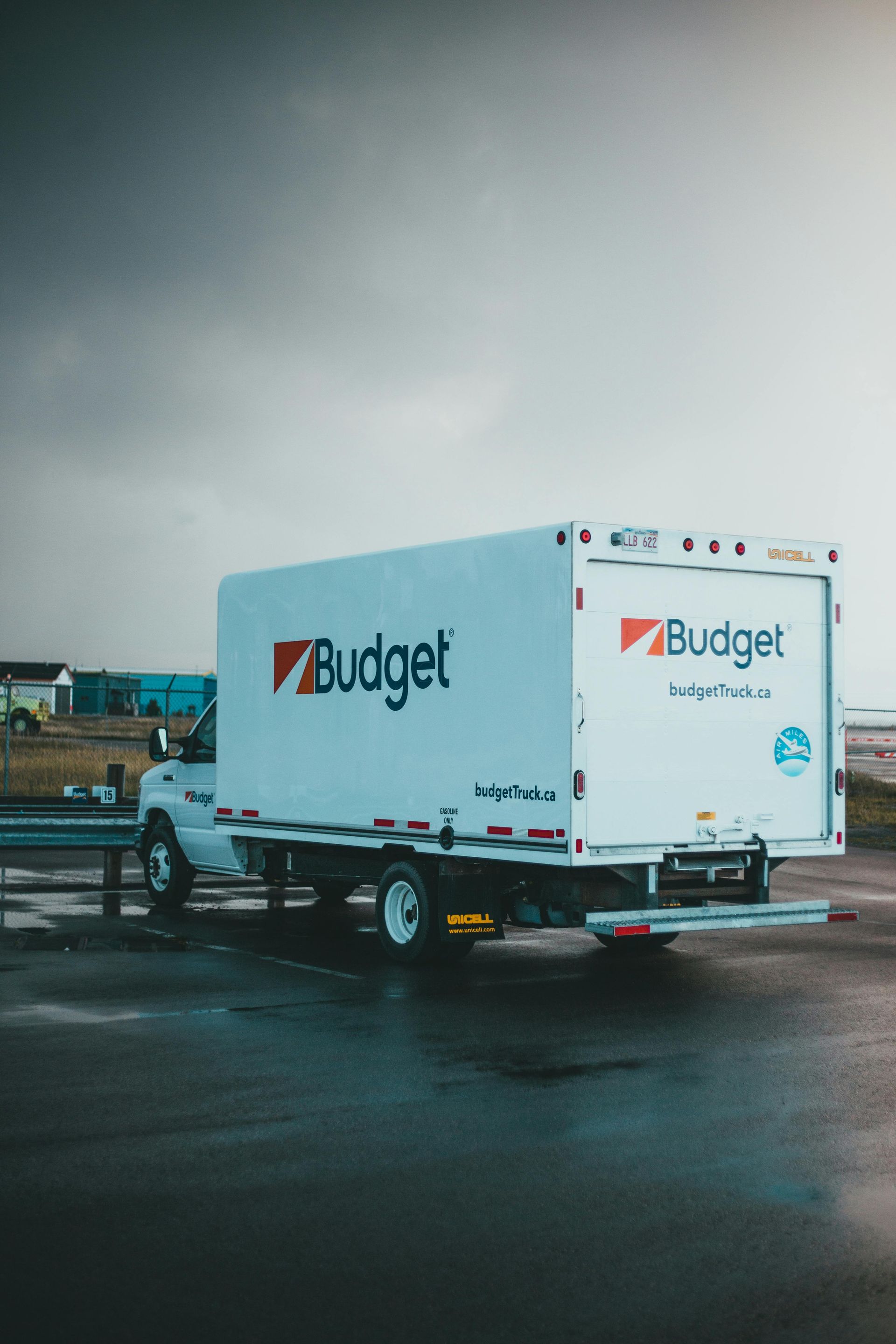 Budget rental truck parked on a wet roadside under a gray sky
