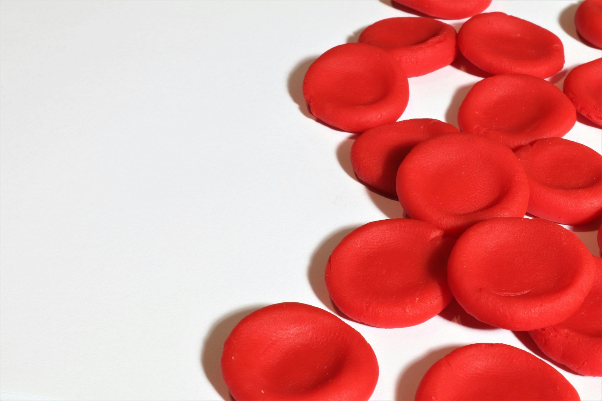 Red poker chips scattered on a white background