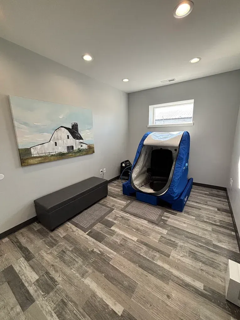 Small room with gray walls, a blue indoor swing seat, bench, and wall art under recessed lights.