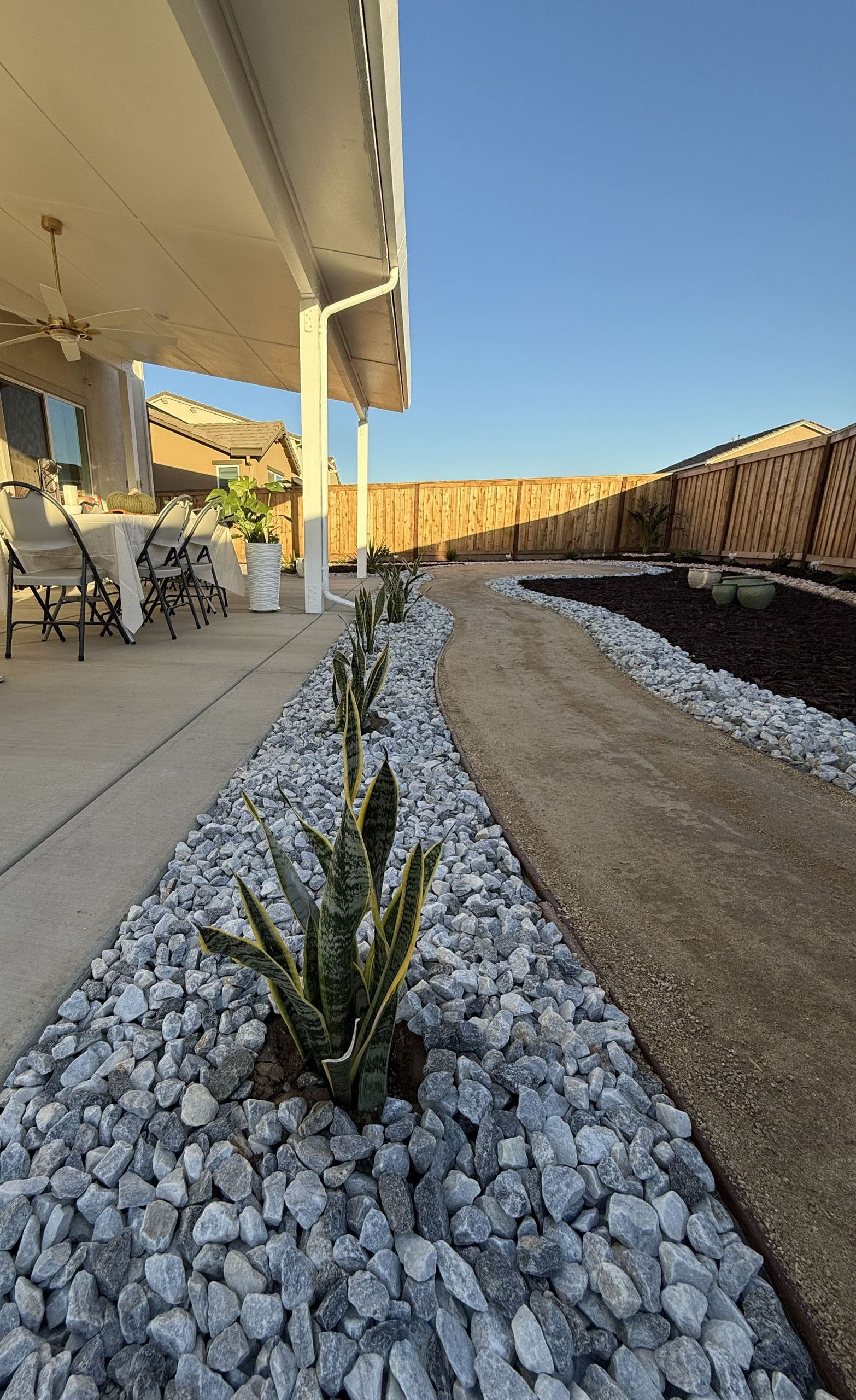 Central Valley backyard landscape design with decorative rock, mulch, and native California plants