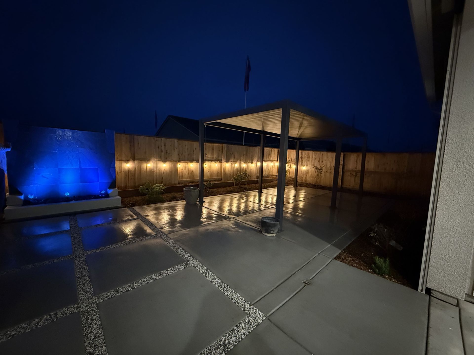 Backyard landscaping built with concrete and lighting, night view in Stockton.
