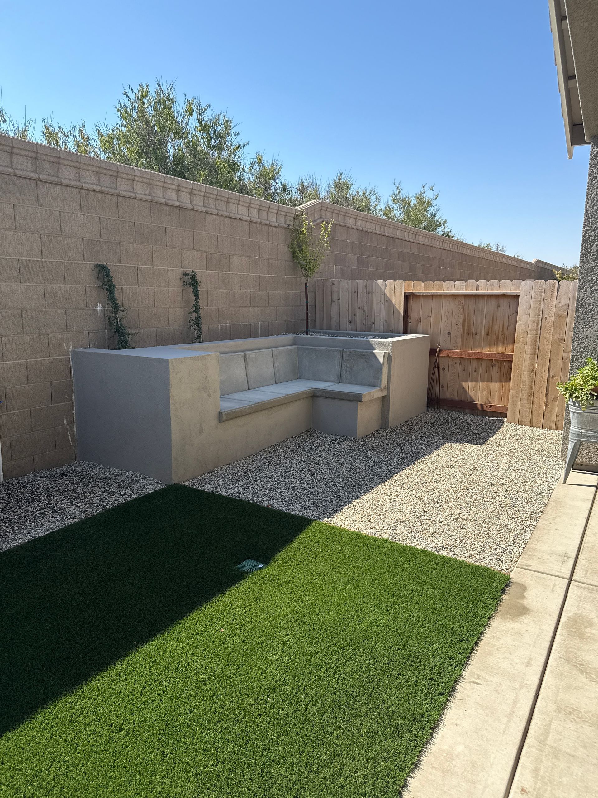 Concrete seating area with green space and modern residential patio design in Stockton CA