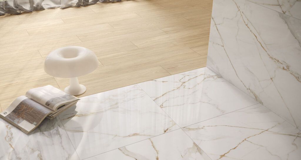 Tazza bianca e pennellino su un pavimento piastrellato beige e bianco, con una parete sullo sfondo.