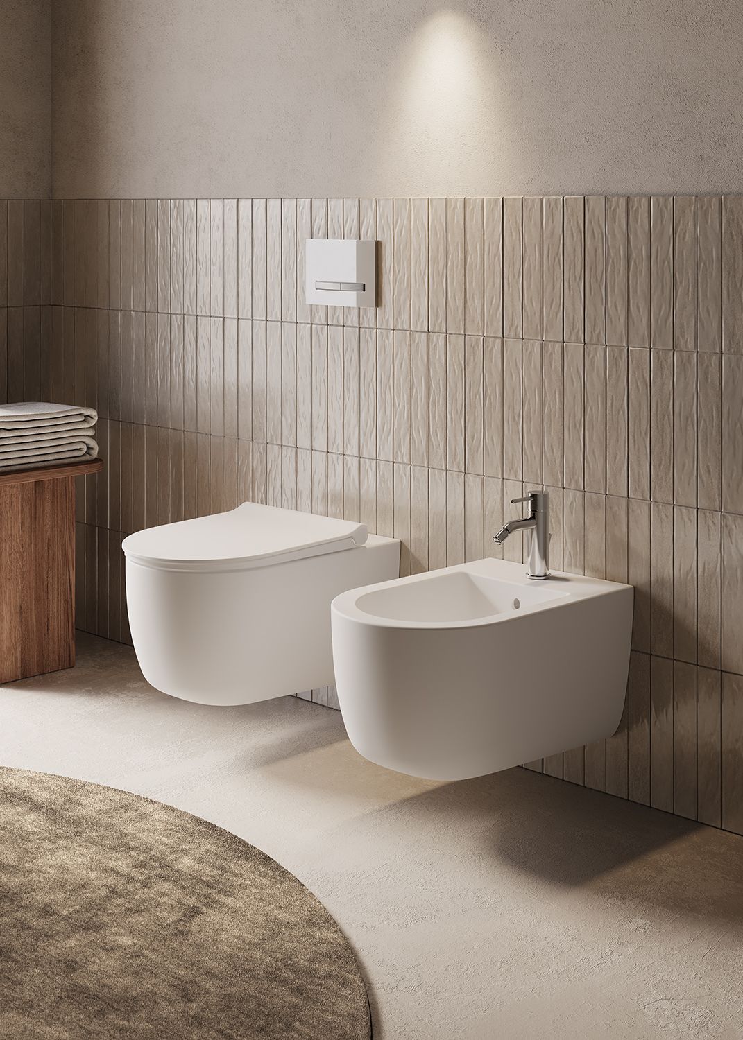 Bagno moderno color beige con WC, bidet, pannello di scarico a parete e tappeto rotondo.