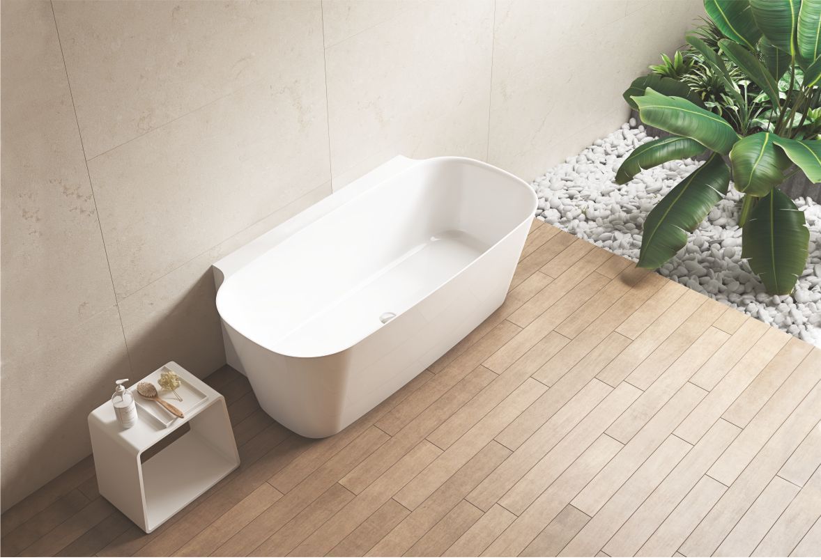 Bagno moderno con vasca bianca, pavimento in legno e una pianta in vaso accanto a un piccolo sgabello.