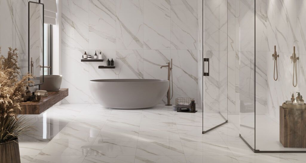 Bagno moderno in marmo con vasca freestanding, doccia in vetro e arredi dai toni neutri e delicati.