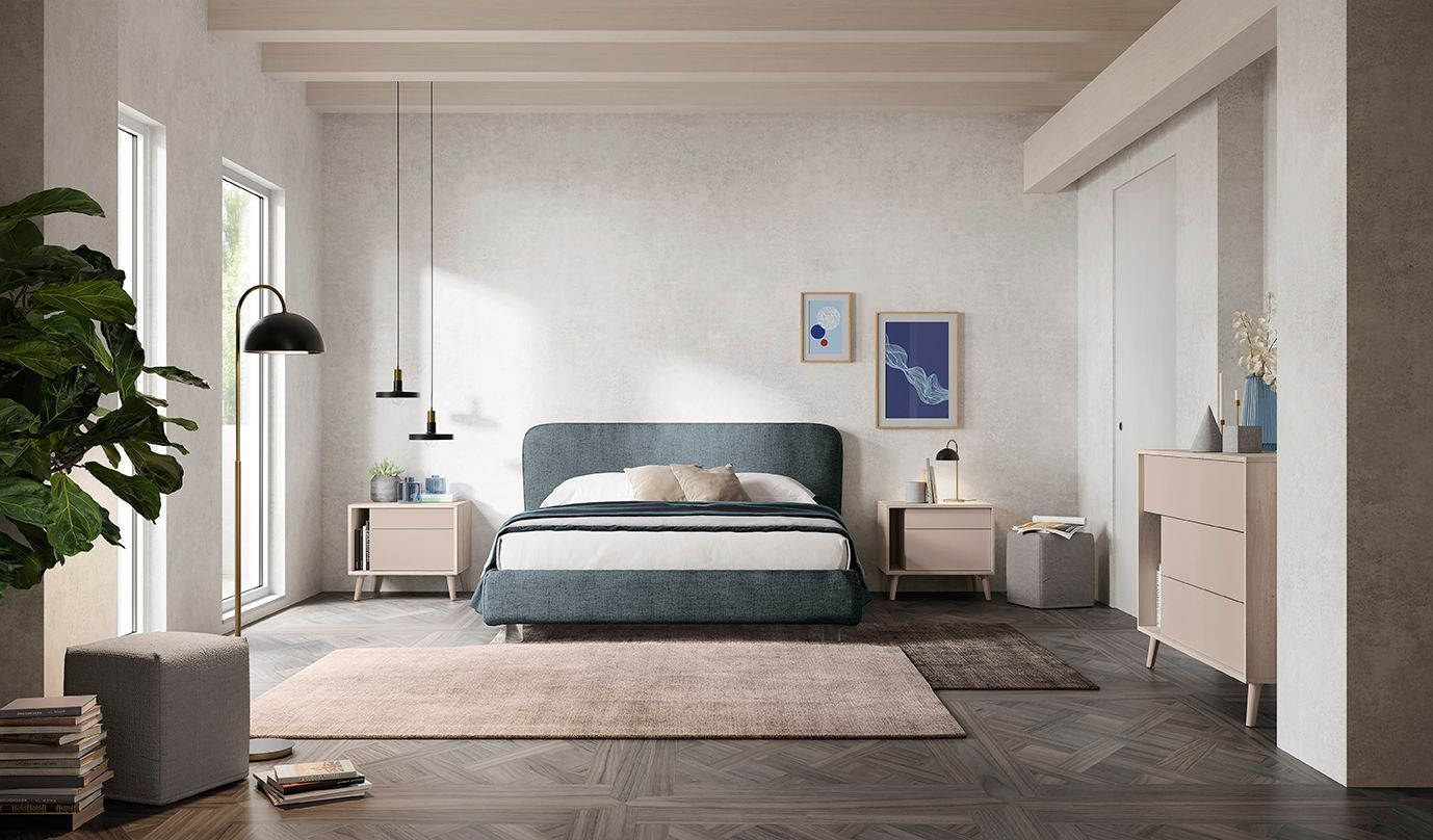 Luminosa camera da letto moderna con letto blu, tappeto beige, piante e arredamento minimalista.