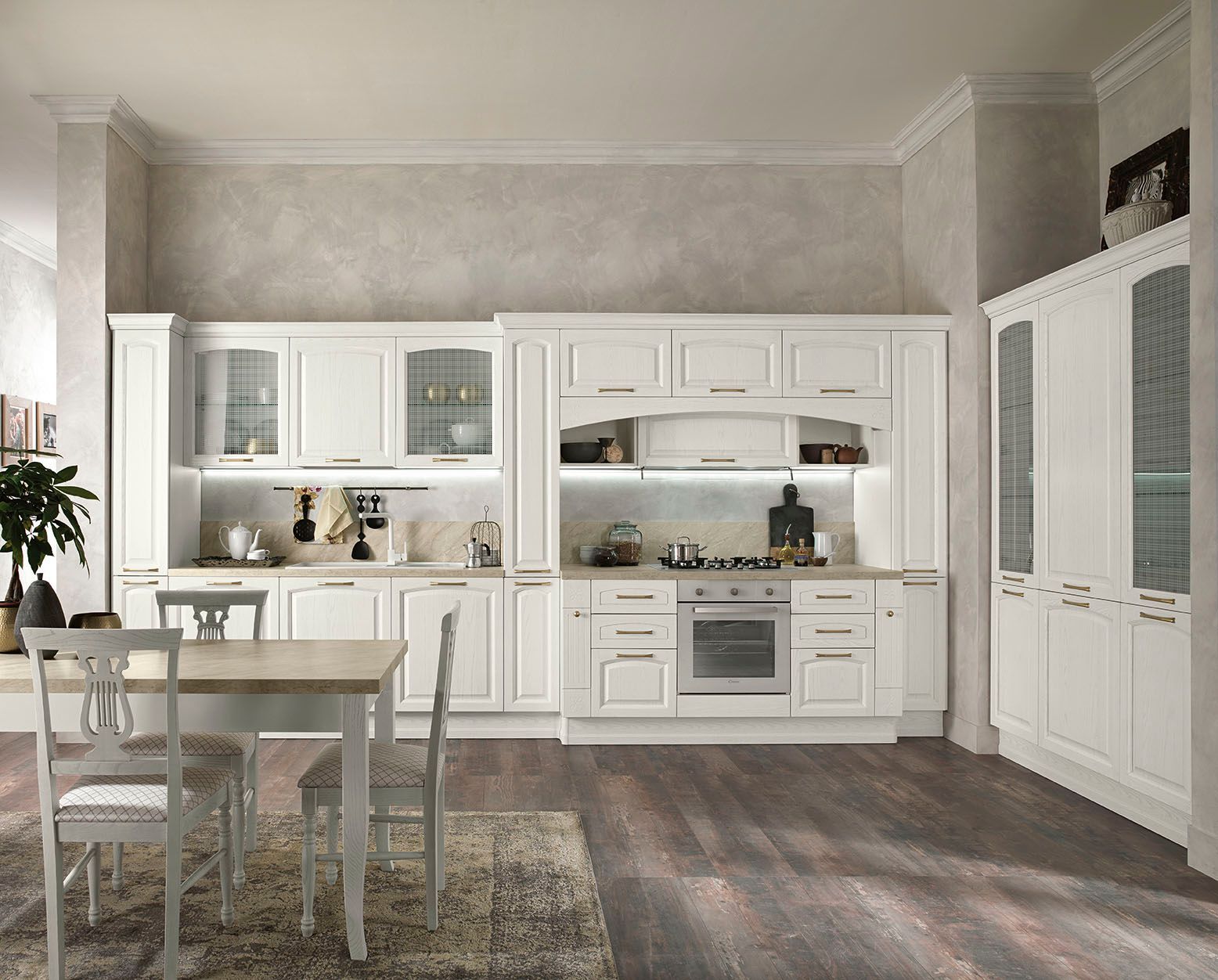 Cucina moderna e luminosa con mobili bianchi, tavolo da pranzo e pavimento in legno scuro.