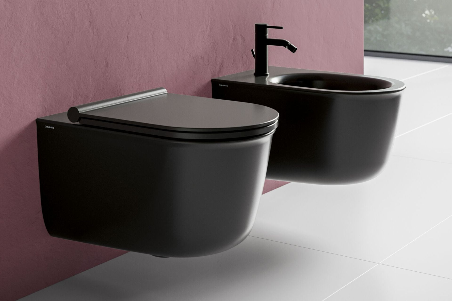 Due WC neri a parete in un bagno moderno con pavimento piastrellato bianco e parete rosa