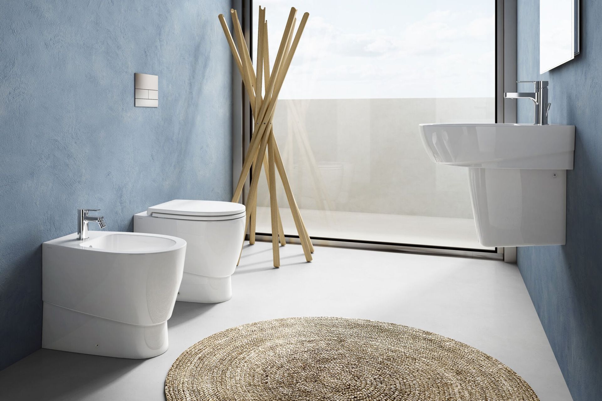 Bagno moderno con sanitari bianchi, pareti blu, portasciugamani in legno e tappeto rotondo accanto alla cabina doccia in vetro.