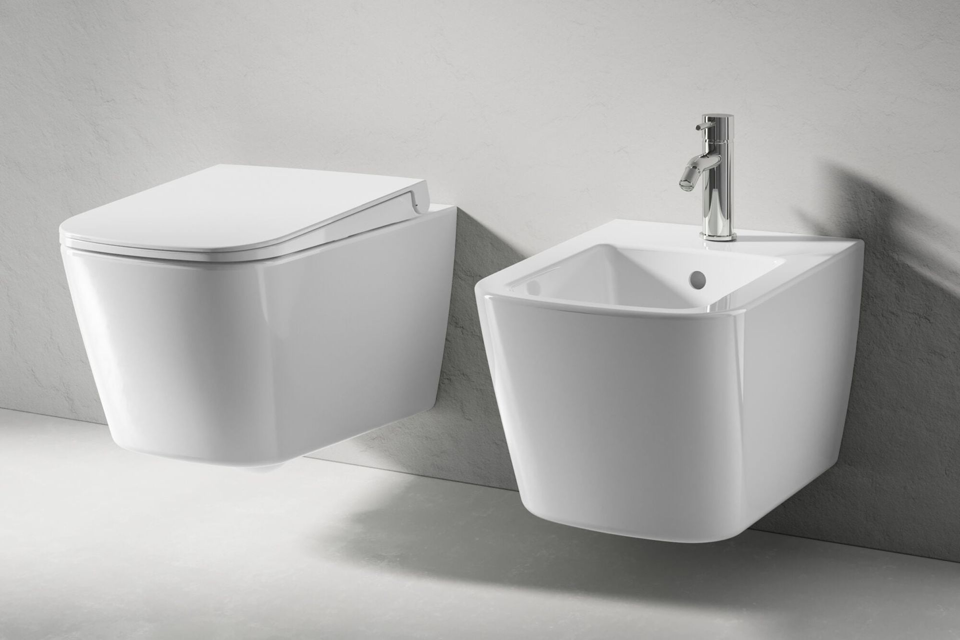 Due moderni sanitari bianchi per il bagno: un WC e un lavabo a parete con rubinetto.