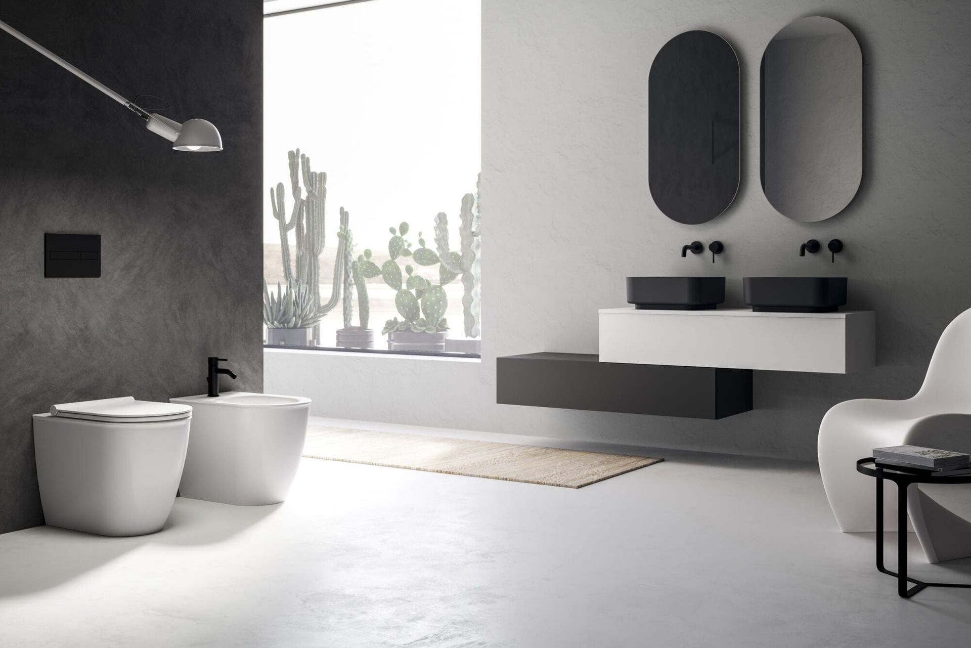 Bagno moderno e minimalista con sanitari bianchi, lavabo sospeso, specchi ovali e ampia finestra.