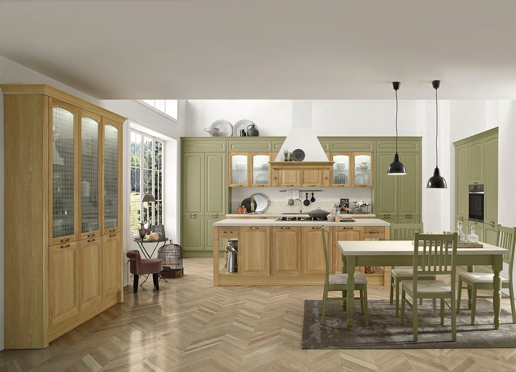 Cucina e sala da pranzo luminose con mobili verdi, arredi in legno e lampade a sospensione.