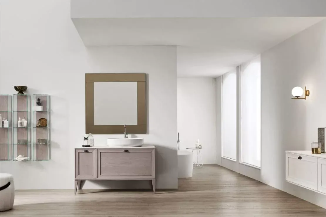 Bagno moderno con mobile lavabo, ampio specchio, applique, vasca e finestre luminose.