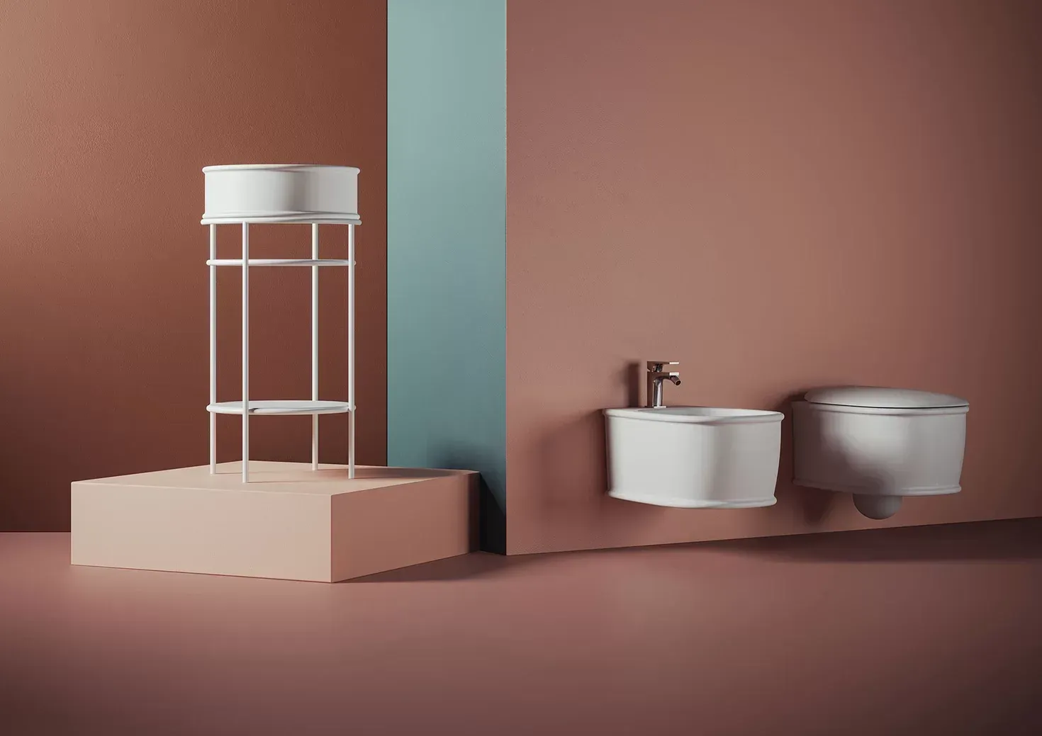 Bagno minimalista con lavabo, WC e mobiletto bianchi su pareti rosa cipria e verde acqua.