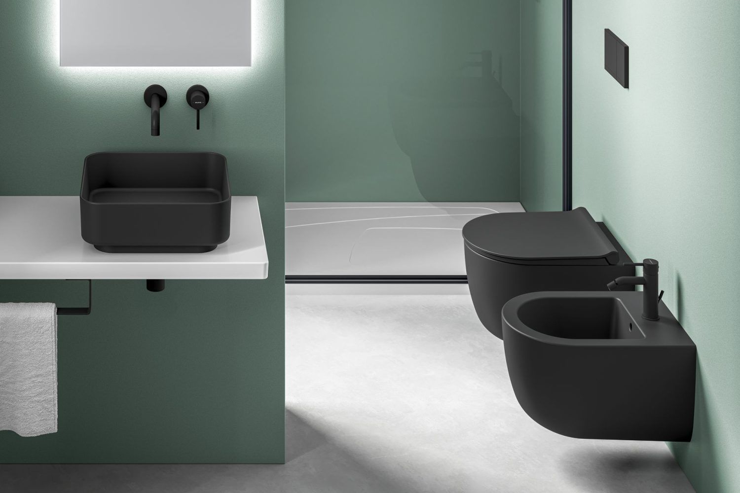 Bagno moderno con lavabo nero opaco, bidet, WC e pareti verde menta.
