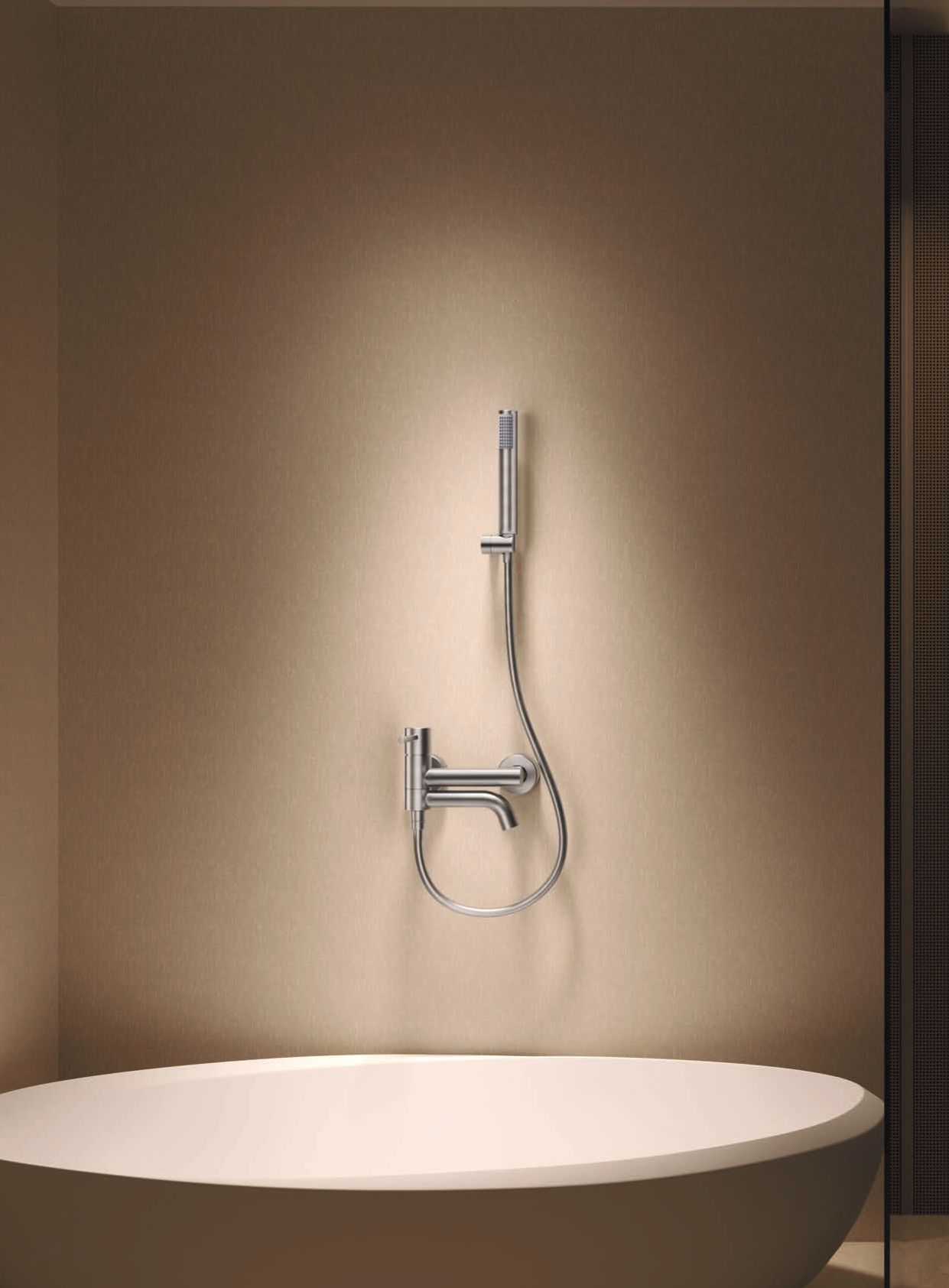 Rubinetto moderno a parete sopra una vasca ovale bianca in un bagno beige.