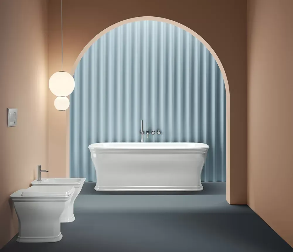 Bagno moderno con WC e vasca bianchi, arco blu e illuminazione a parete soffusa.