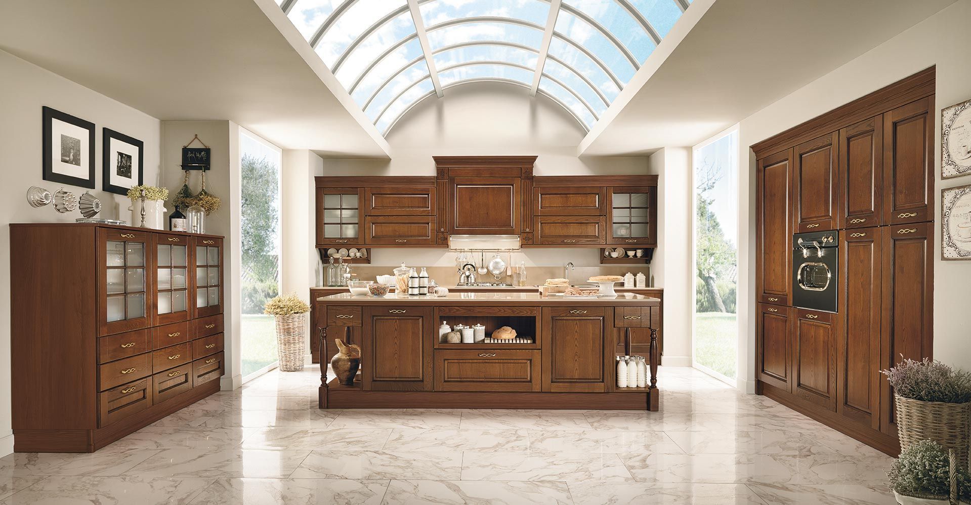 Elegante cucina con mobili in legno decorati, isola centrale e soffitto ad arco con lucernario.