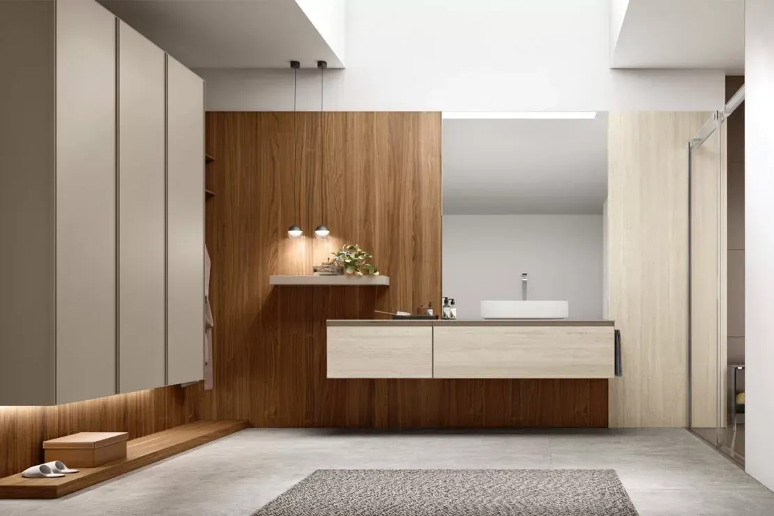 Bagno moderno e minimalista con mobiletto in legno, lavabo bianco, ampio specchio e tonalità neutre.