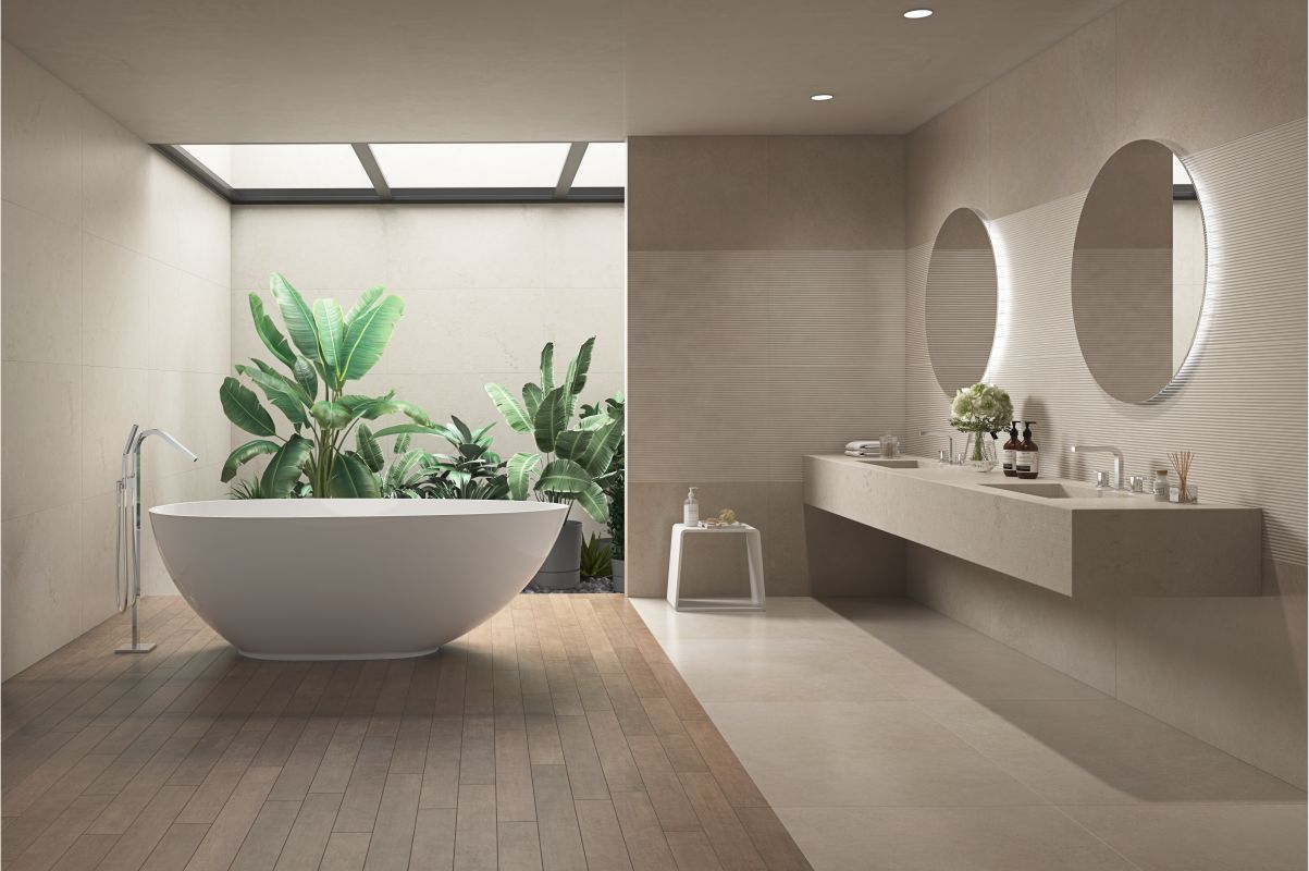 Bagno moderno con vasca freestanding, lucernario, pavimento in legno, mobile lavabo sospeso e specchio rotondo con piante.