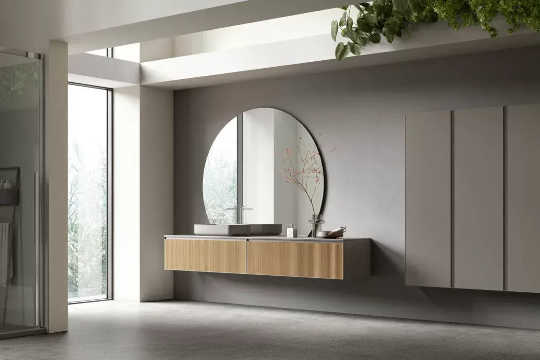 Area reception moderna e minimalista con scrivania sospesa in legno, specchio ad arco e pareti grigio chiaro.
