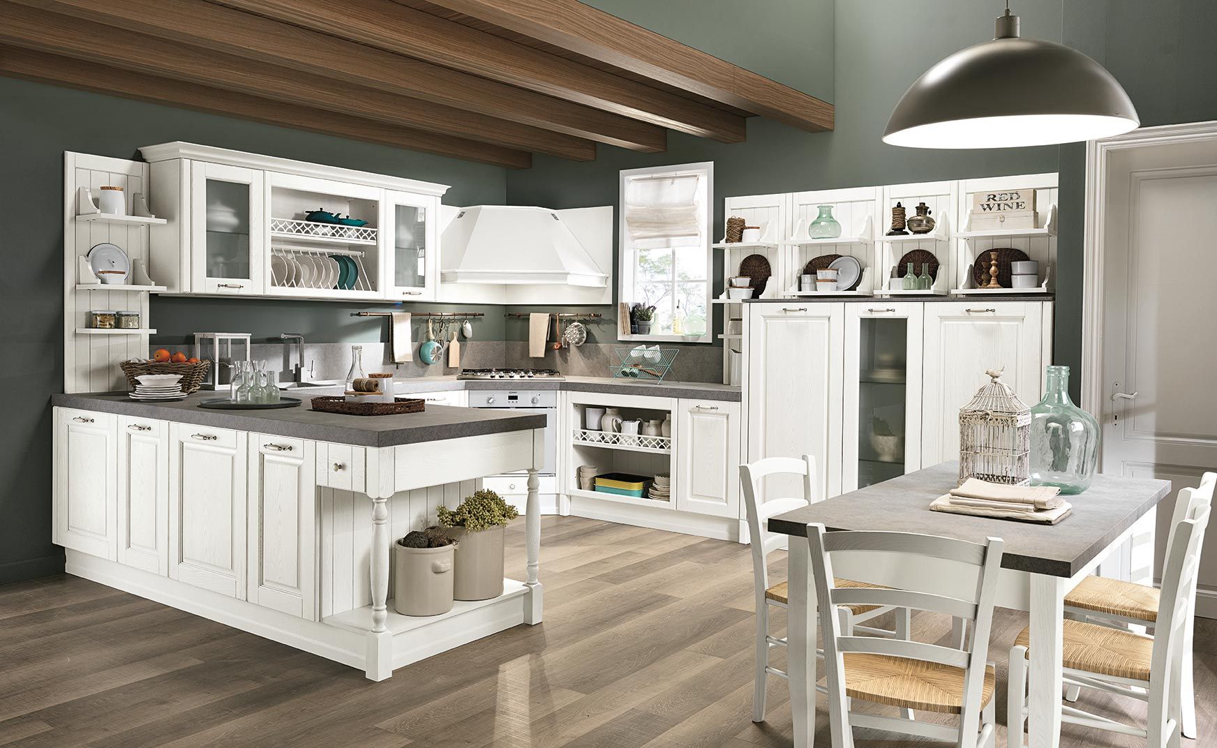 Cucina in stile rustico, luminosa e bianca, con isola centrale, mobili, travi in ​​legno e tavolo da pranzo in delicate tonalità neutre.