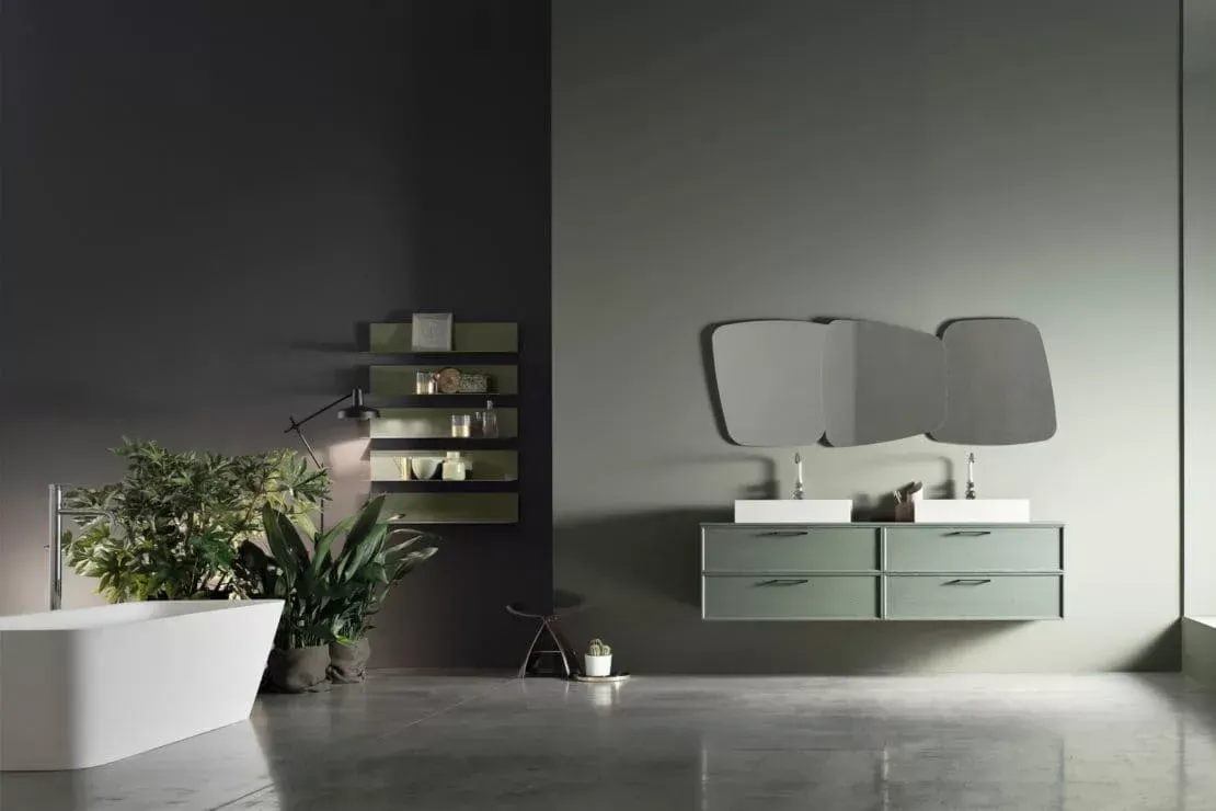 Bagno moderno con specchio a parete, mobile lavabo bianco, piante e pavimento piastrellato grigio con illuminazione soffusa.