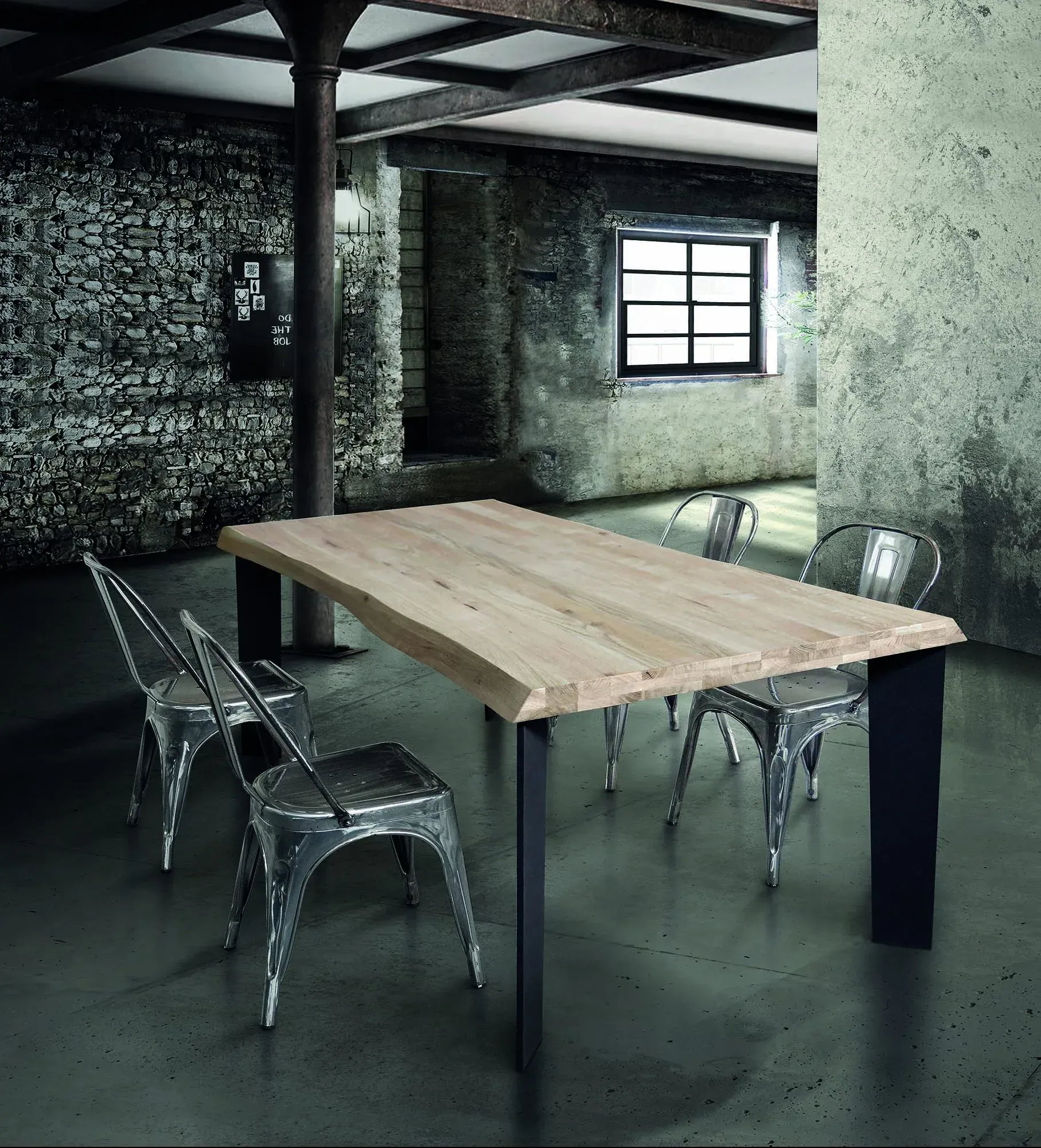 Stanza moderna in stile industriale con tavolo in legno e sedie trasparenti vicino a una finestra.