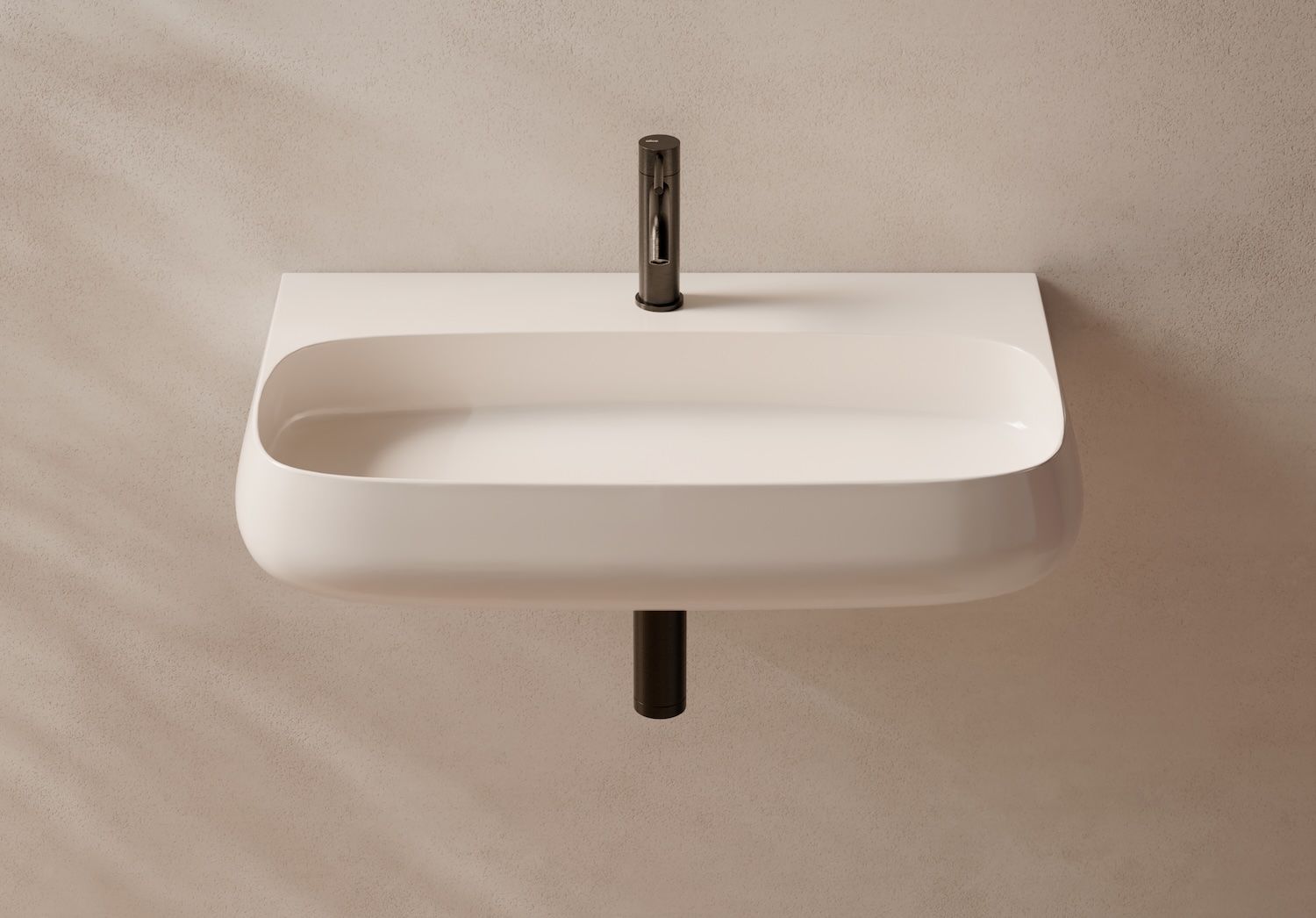 Lavabo bianco a parete con rubinetto cromato e tubo di scarico nero, su una parete beige.