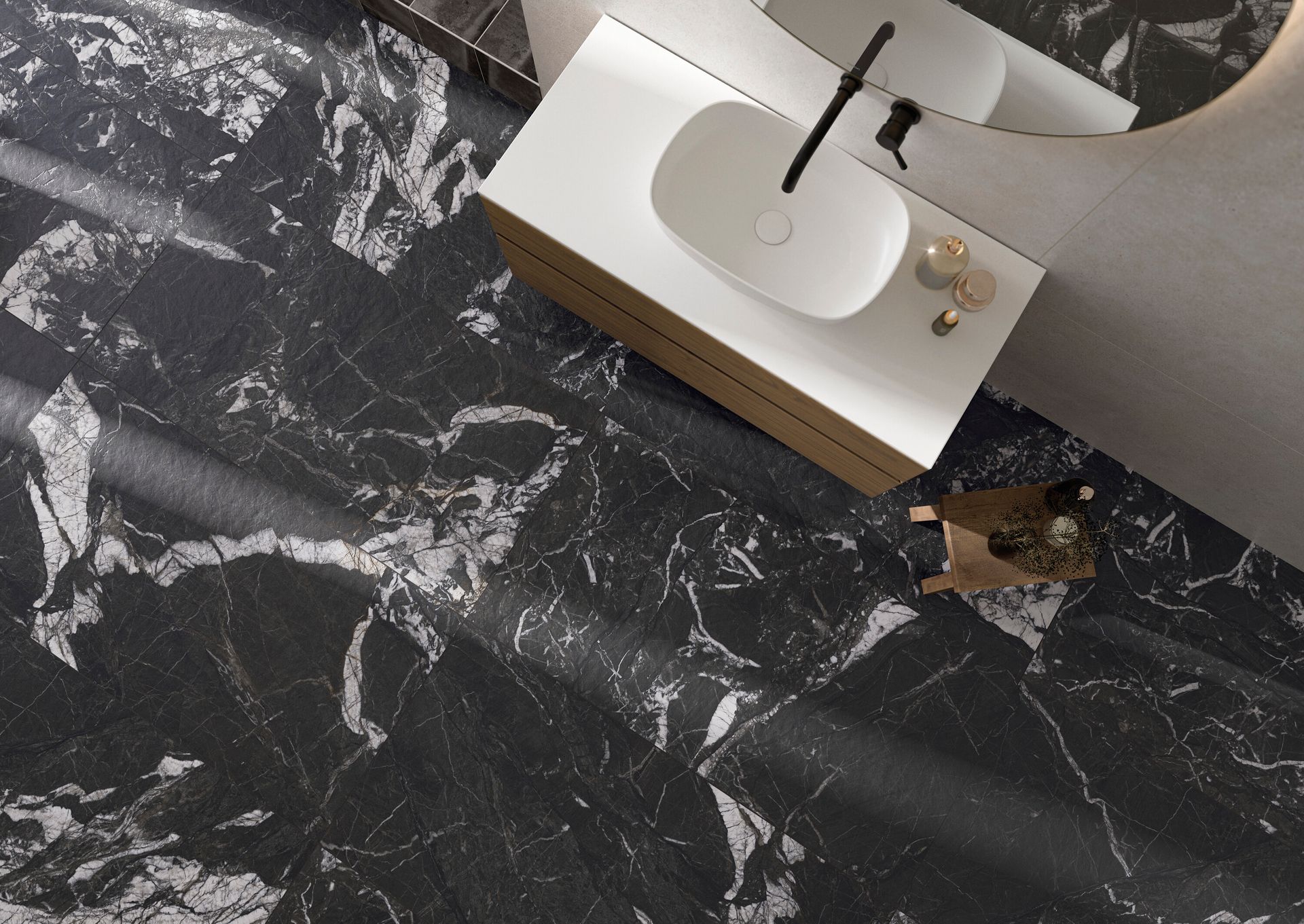 Pavimento del bagno in marmo nero con lavabo bianco e un piccolo cane marrone vicino al mobiletto del bagno.