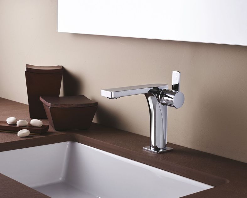Bagno moderno con mobile lavabo blu, specchio ad arco, vasca freestanding e piastrelle a pavimento con effetto maculato.