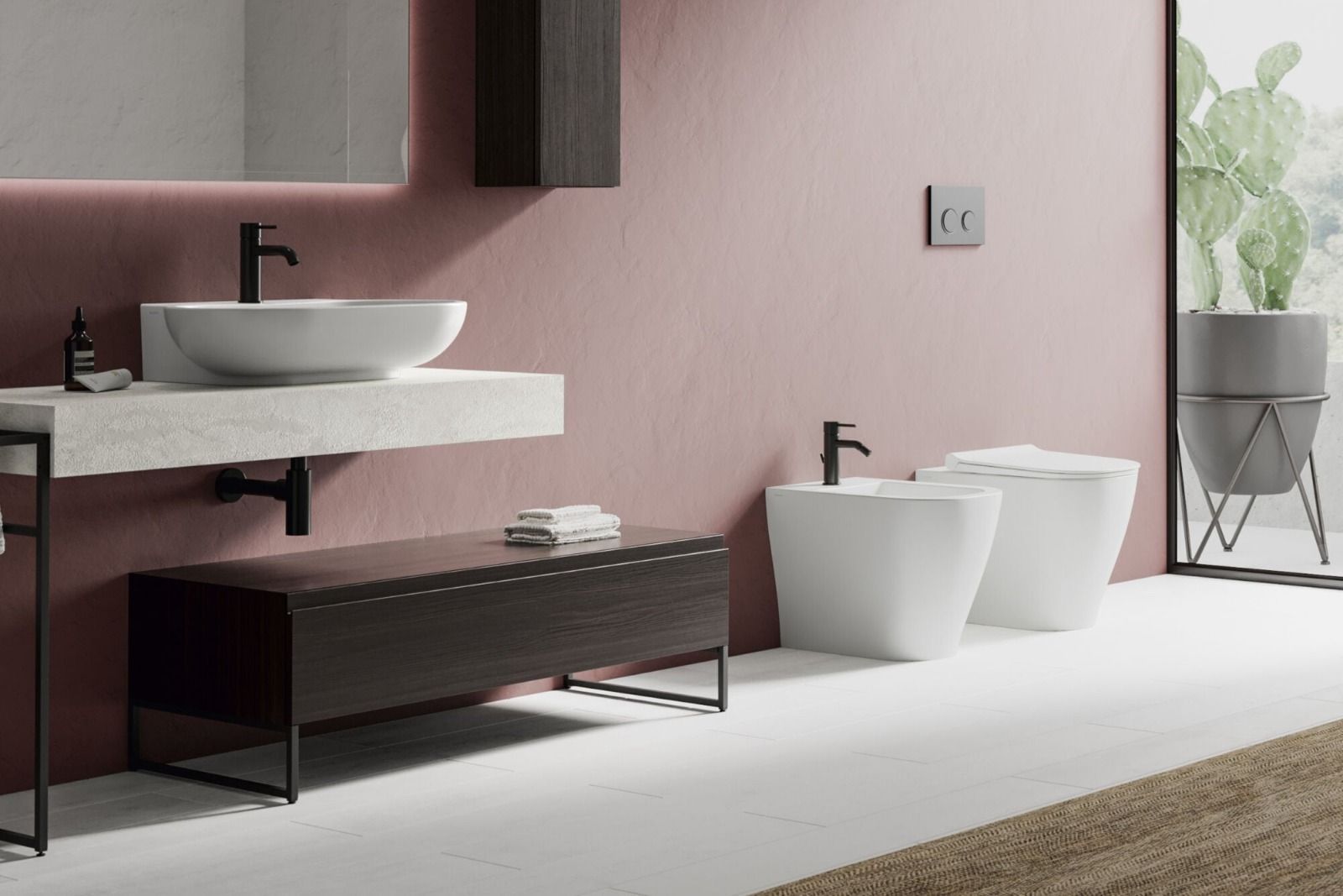Bagno moderno con pareti rosa, lavabo sospeso, vasca e due lavabi bianchi a pavimento accanto a una finestra.