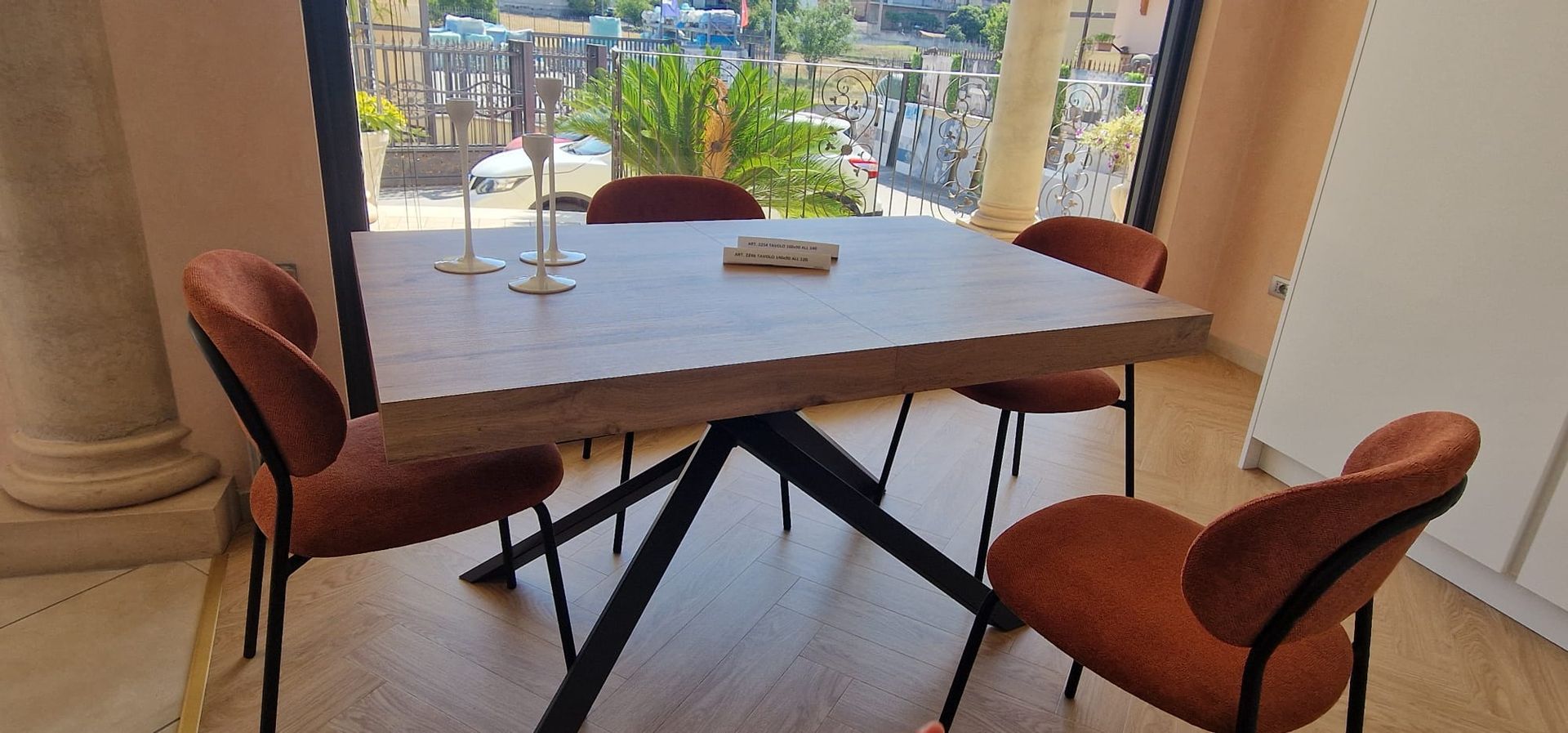 Tavolo da pranzo moderno con quattro sedie accanto a una grande finestra con vista sulla città.