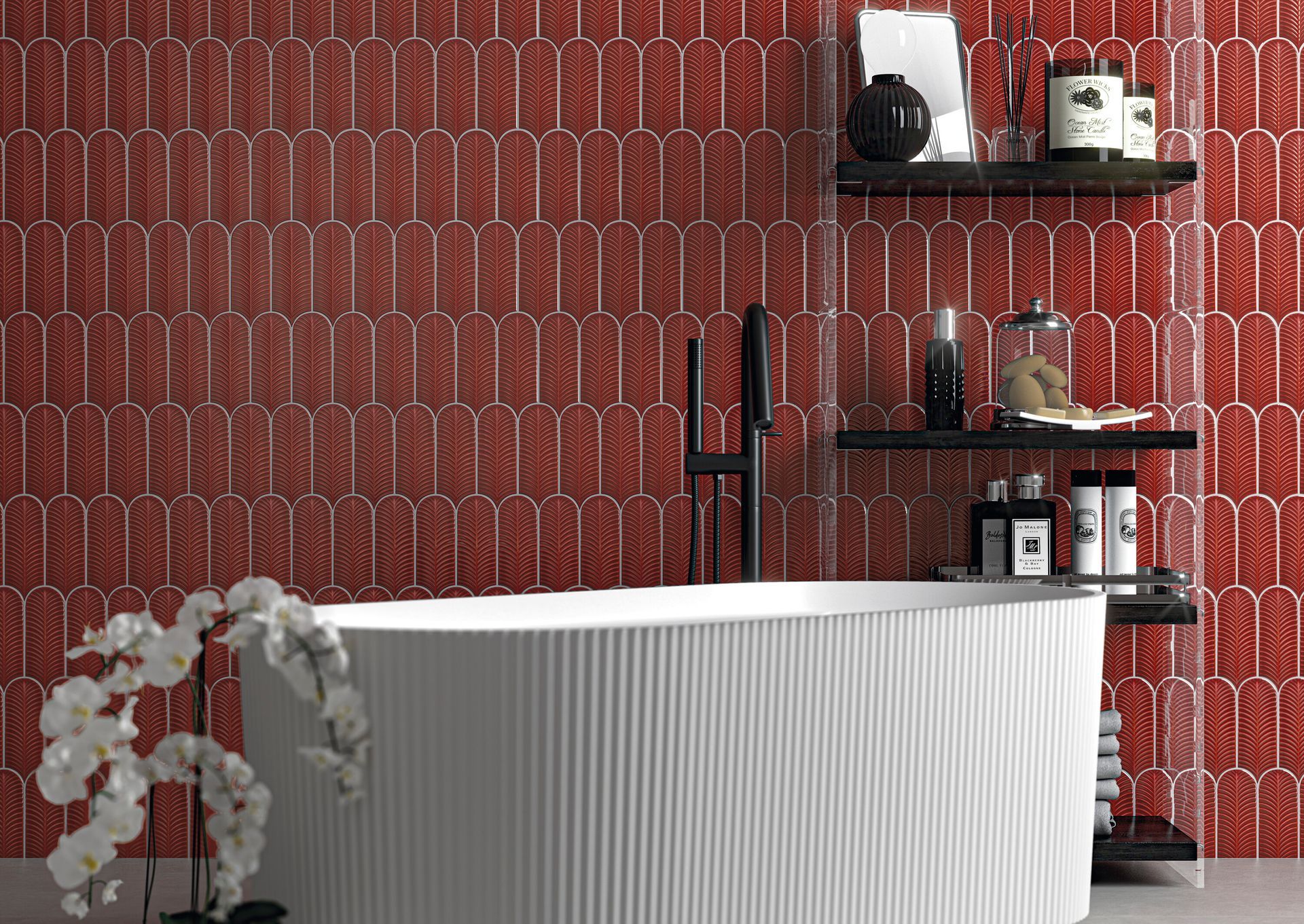 Bagno moderno con vasca freestanding bianca, parete rivestita con piastrelle rosse decorate e mensole nere con oggetti decorativi e bottiglie.