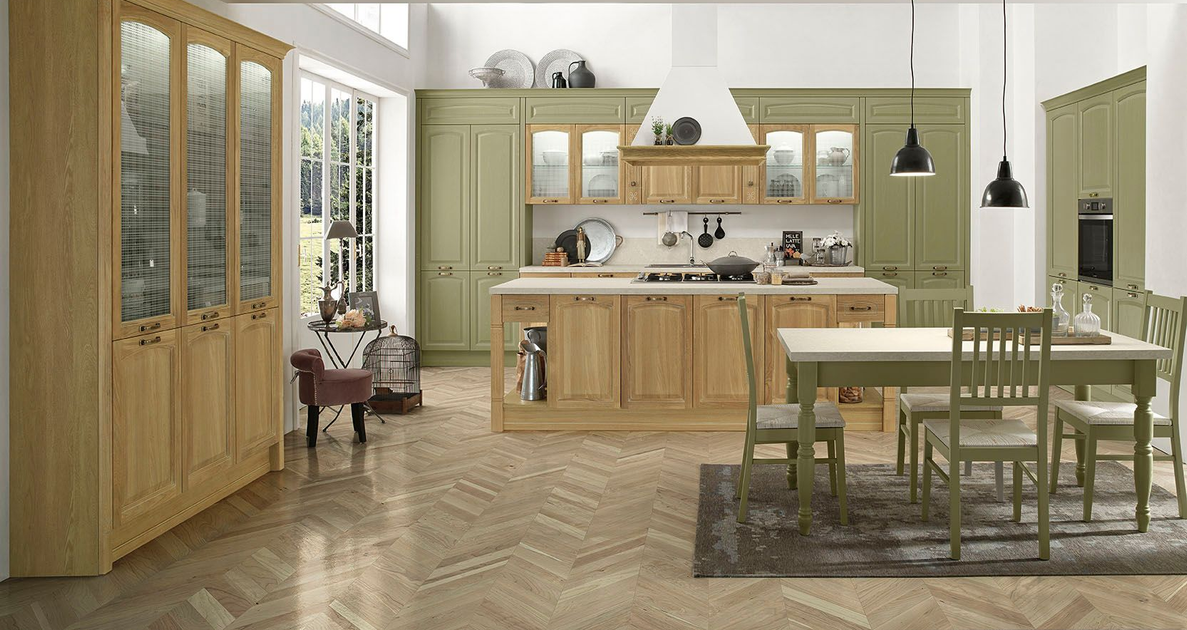 Cucina luminosa in stile rustico con mobili in legno, pavimento a spina di pesce, isola, tavolo da pranzo e lampade a sospensione nere.