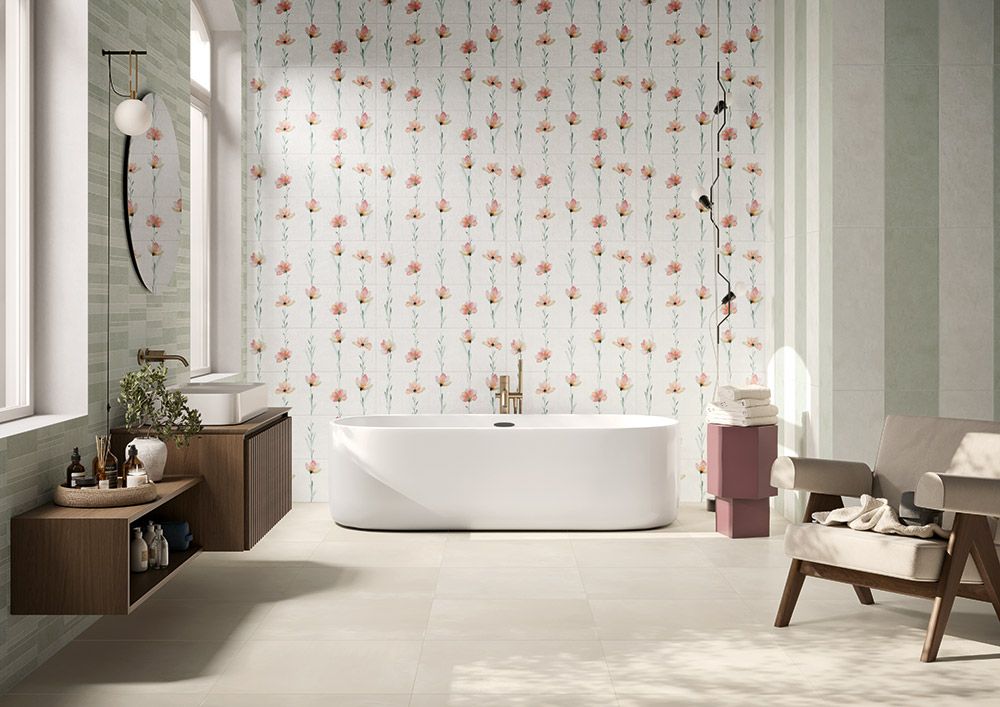 Bagno minimalista con vasca bianca, tenda a fiori, panca in legno e sedia in delicate tonalità neutre.