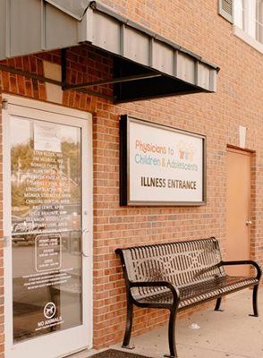 Exterior of a medical clinic: brick building, awning, sign reading 